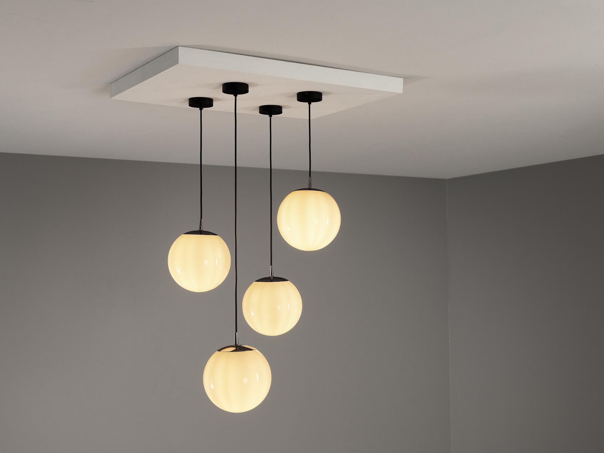 Pendants, glass, chrome-plated metal, Europe, 1960s

These atmospheric pendant lamps features each an opaque white glass orb. This results in a nice and soft light-tone creating a lively ambience in the room. The lamps can be hung above a large