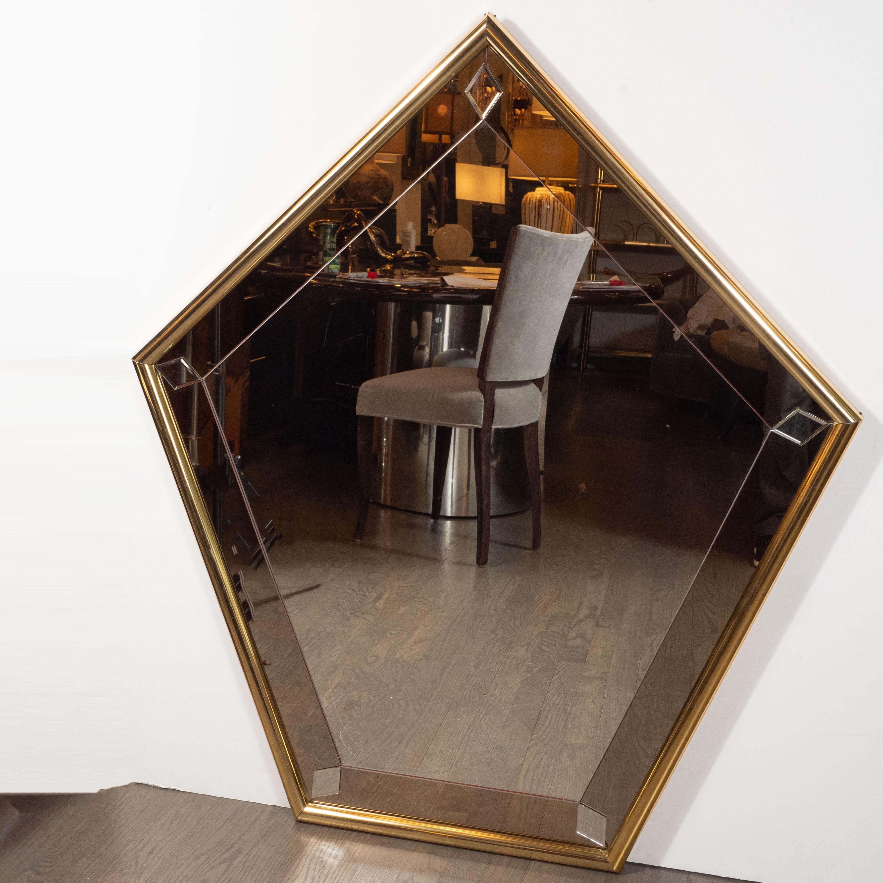 This bold and sophisticated mirror was realized in the United States, circa 1970. It features a pentagonal form wrapped in cylindrical brass with a smoked mirror border. Mirrored rhomboid star form embellishments sit in each of the interior angles,