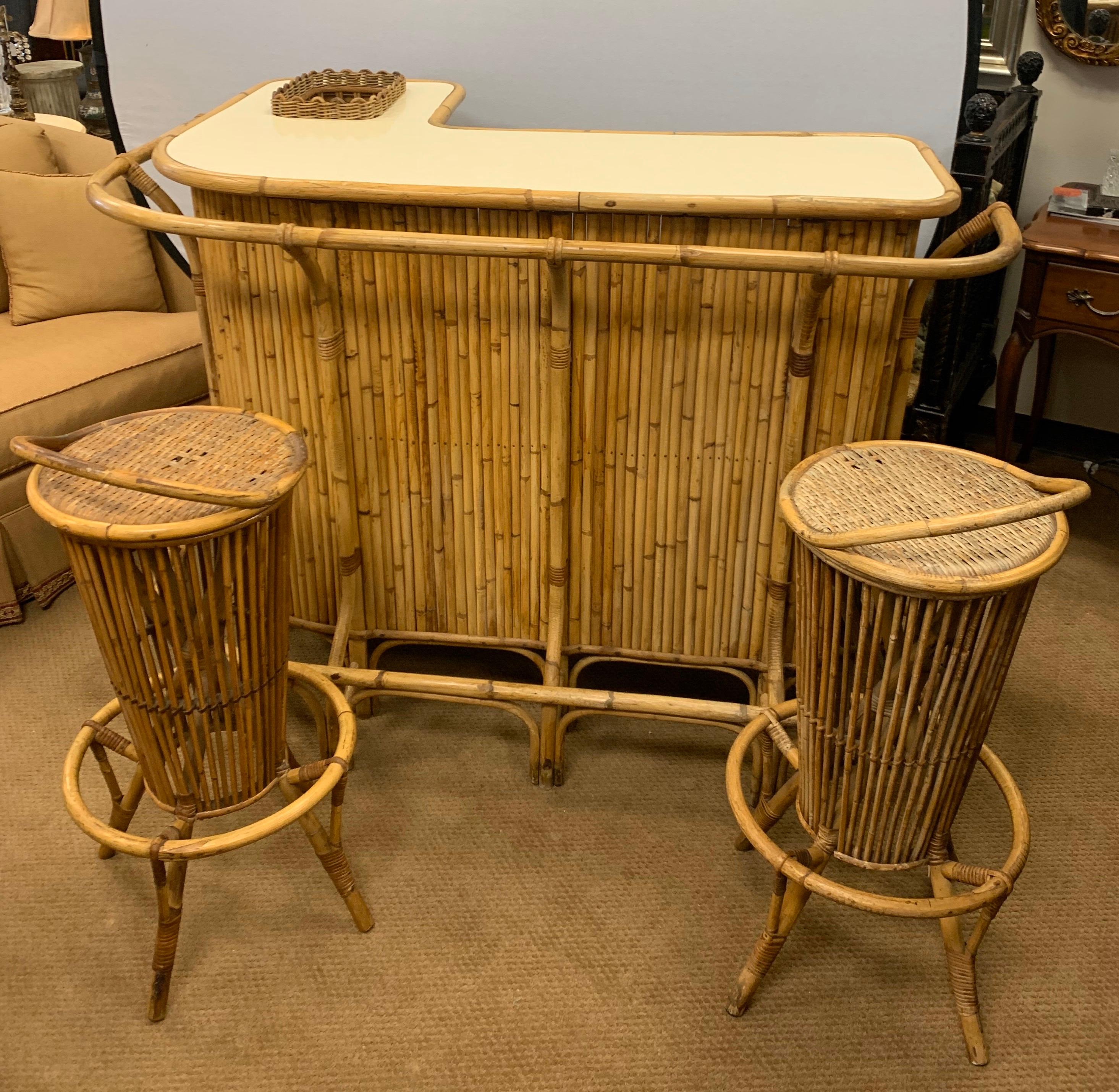 Mid-Century Modern 1970s three-piece matching bamboo bar with Formica top. Features plenty of storage, a drop in ice area and two matching stools. It has been preserved by original Palm Springs, CA owner. All dimensions are below for the bar. The
