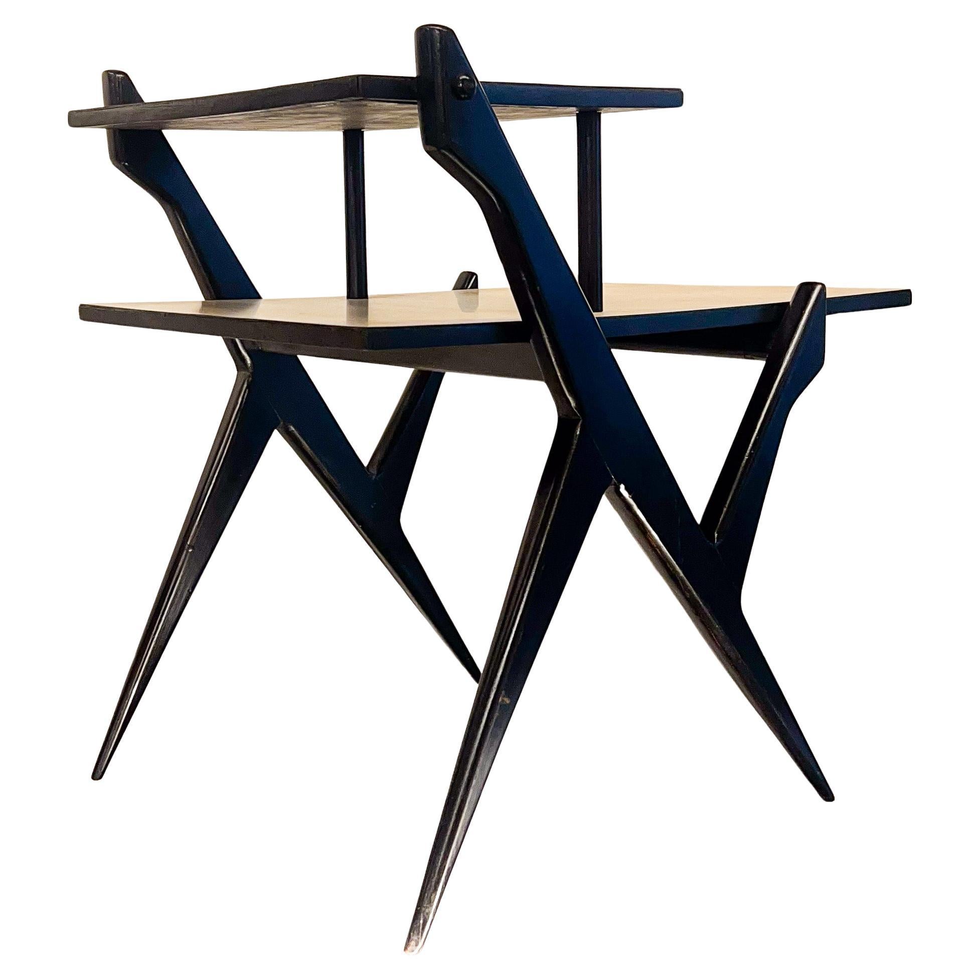Disponible dès aujourd'hui, cette table téléphonique unique en son genre, fabriquée dans les années 50, est un véritable coup de cœur !

La pièce est fabriquée en bois dur et en contreplaqué et comporte deux étagères avec un plateau en formica gris
