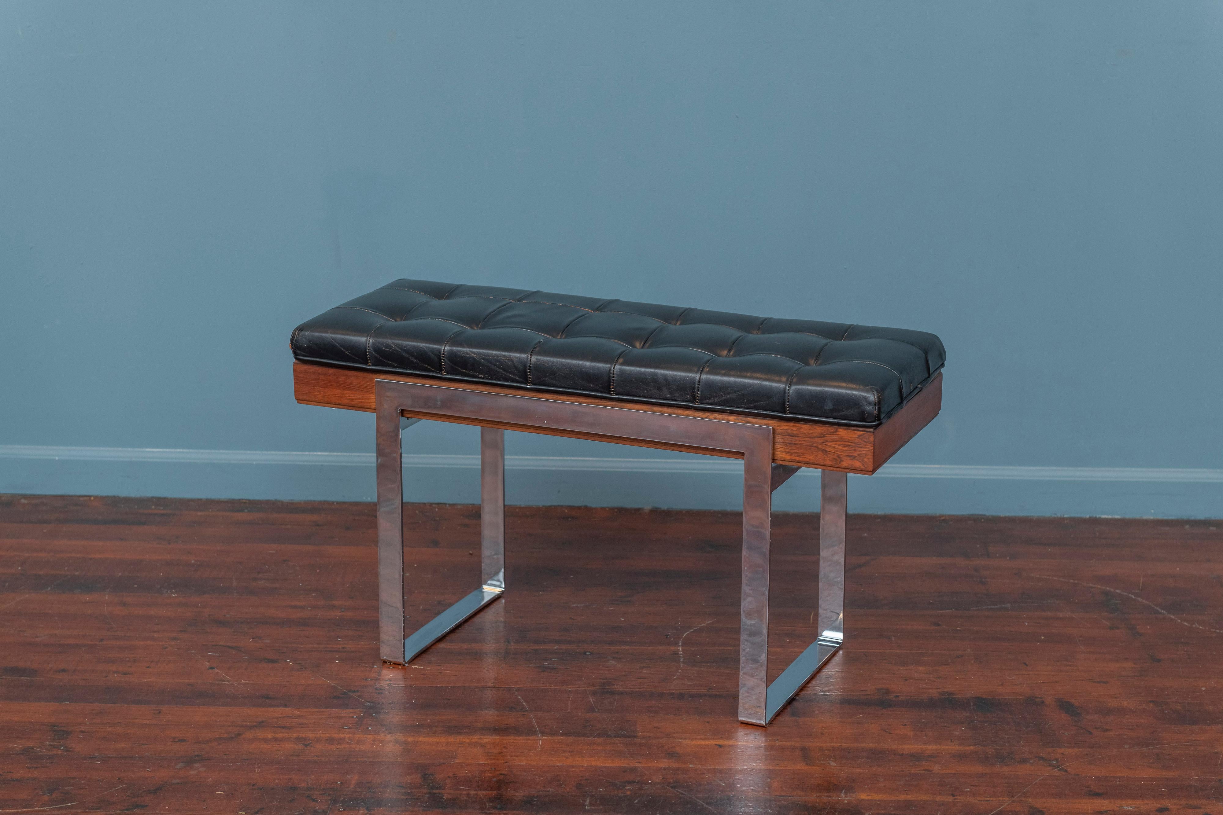 Mid-Century modern piano bench or entry way stool by Kimball Manufacturing co. Executed in a black tufted leather seat on a rosewood box frame and supported by solid chrome plated steel legs. Made from high quality materials and construction this