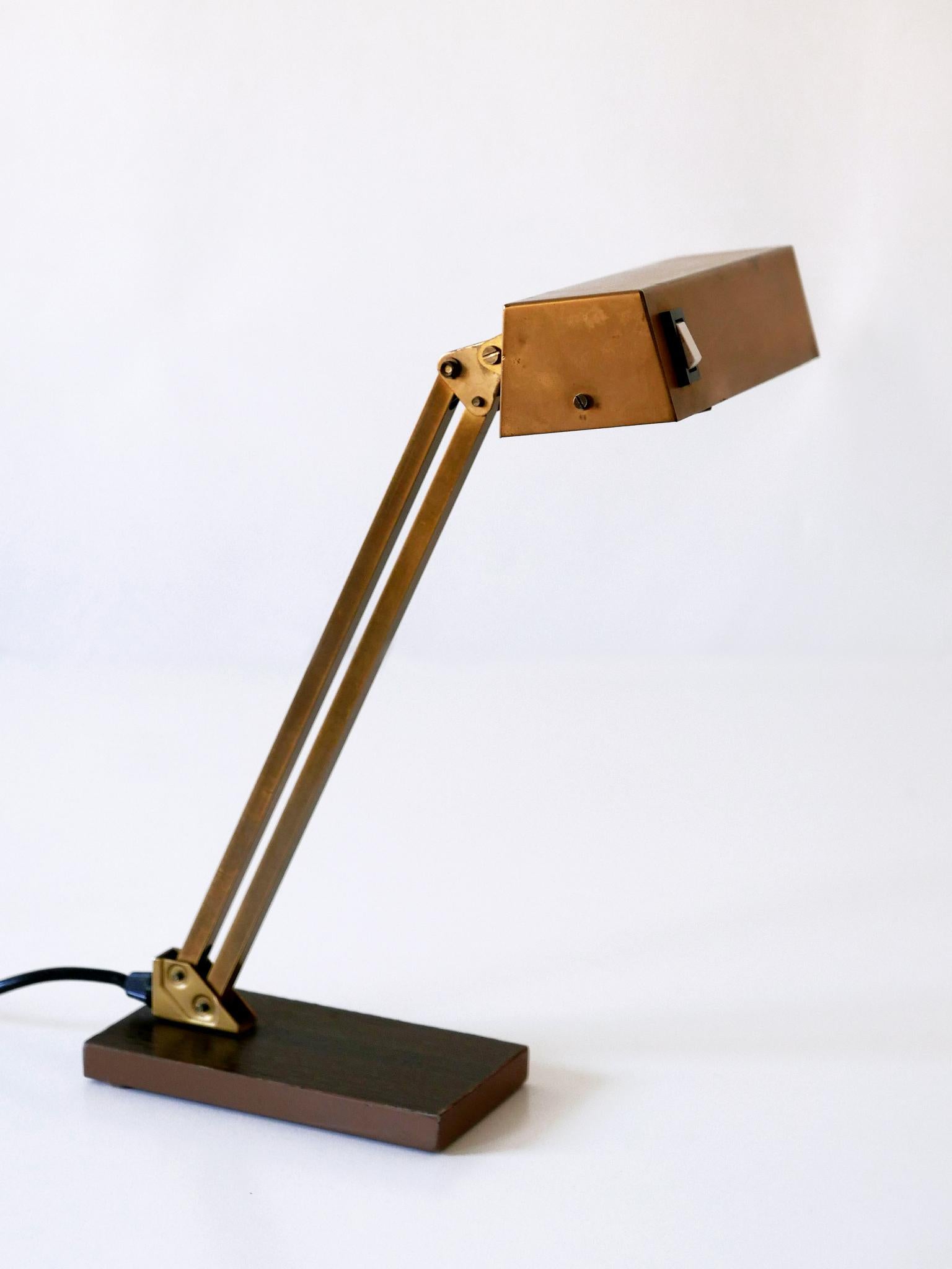 Elegant Mid-Century Modern piano lamp or desk light. Manufactured by Pfäffle Leuchten, 1960s, Germany. Adjustable height and shade.

Executed in brass, steel and cast iron, the piano lamp comes with 1 x E14 / E12 Edison screw fit bulb holder, is