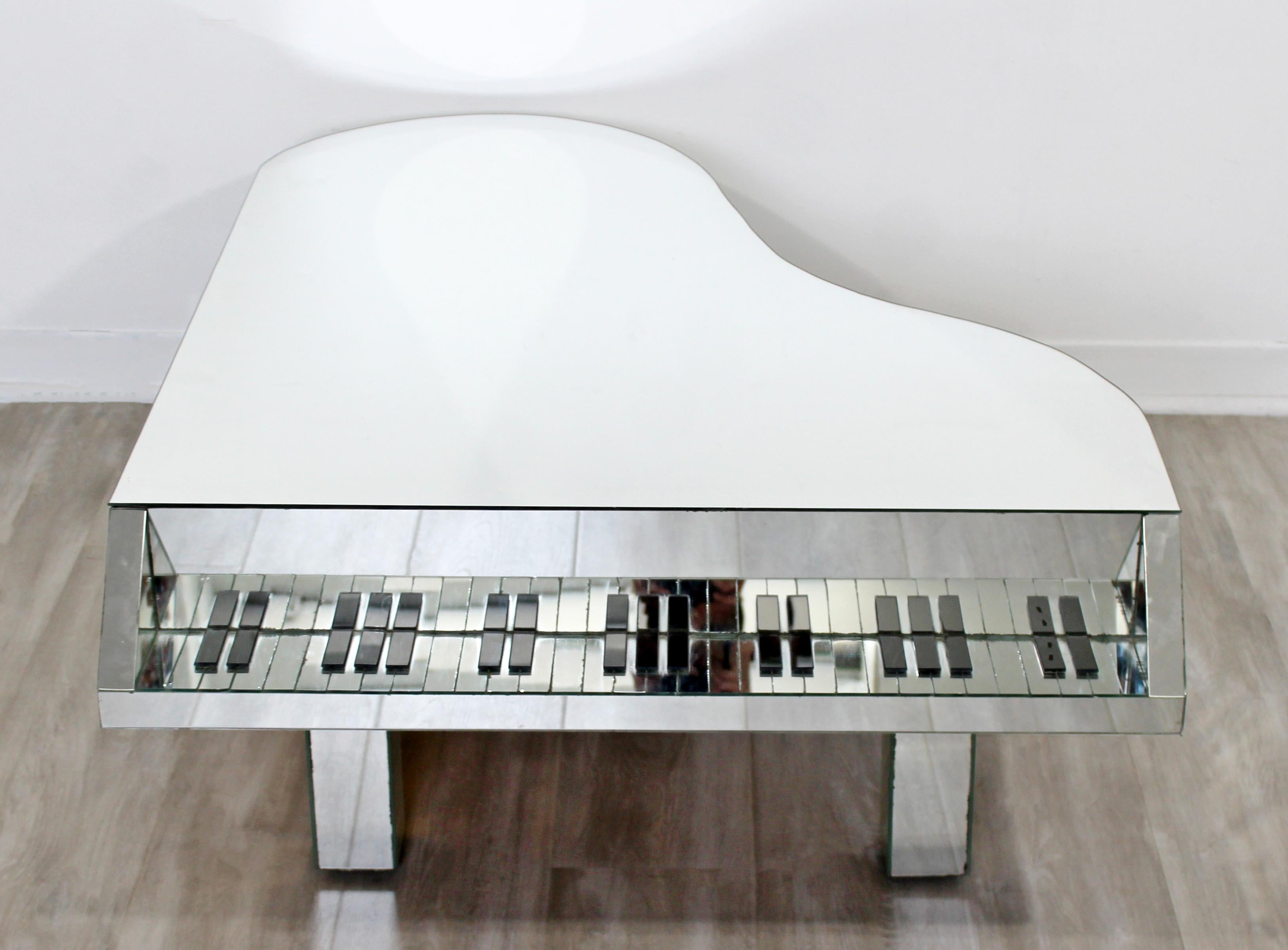 For your consideration is a fabulously eccentric, piano shaped cocktail or coffee table, made of mirrored glass, circa the 1970s. In good vintage condition, with one of the pieces having a slight chip which can easily be replaced. The dimensions are
