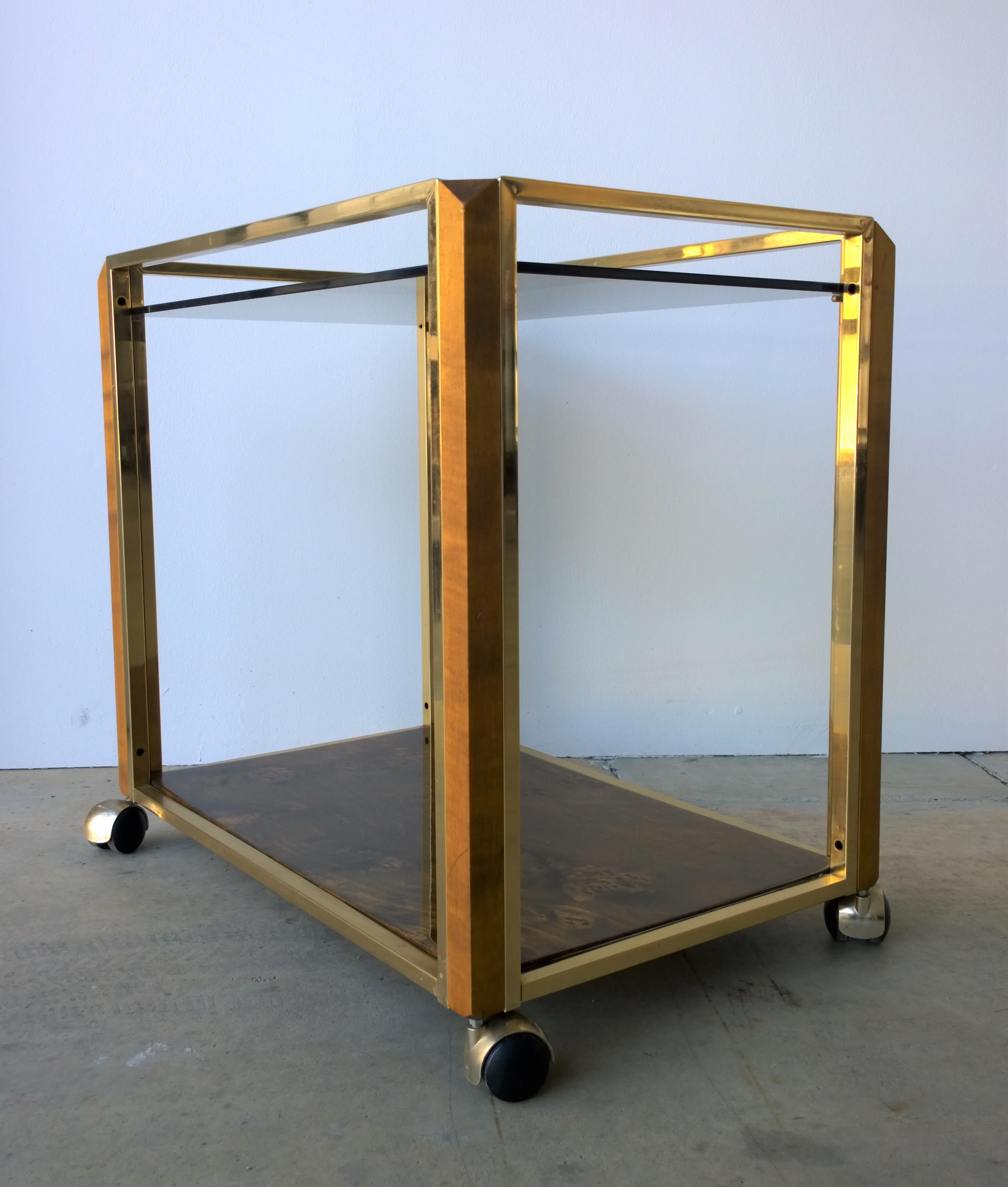 Offered is a Mid-Century Modern Pierre Carding style lacquered brass, wood, glass and clear lacquered burled wood veneer bar or drinks cart. This piece is quite elegant and would fit easily with any type of decor. We suggest requesting additional