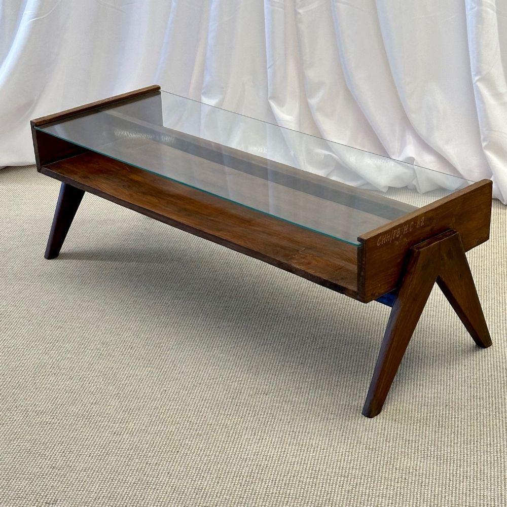 Pierre Jeanneret Rectangular glass coffee table, Model PJ-TB-05-A
 
This collector's coffee table features the signature cpmpass V-leg base, open cabinet concept center shelf, glass top and tapered legs. 
 
France, India, c. 1960s
Teak, glass.