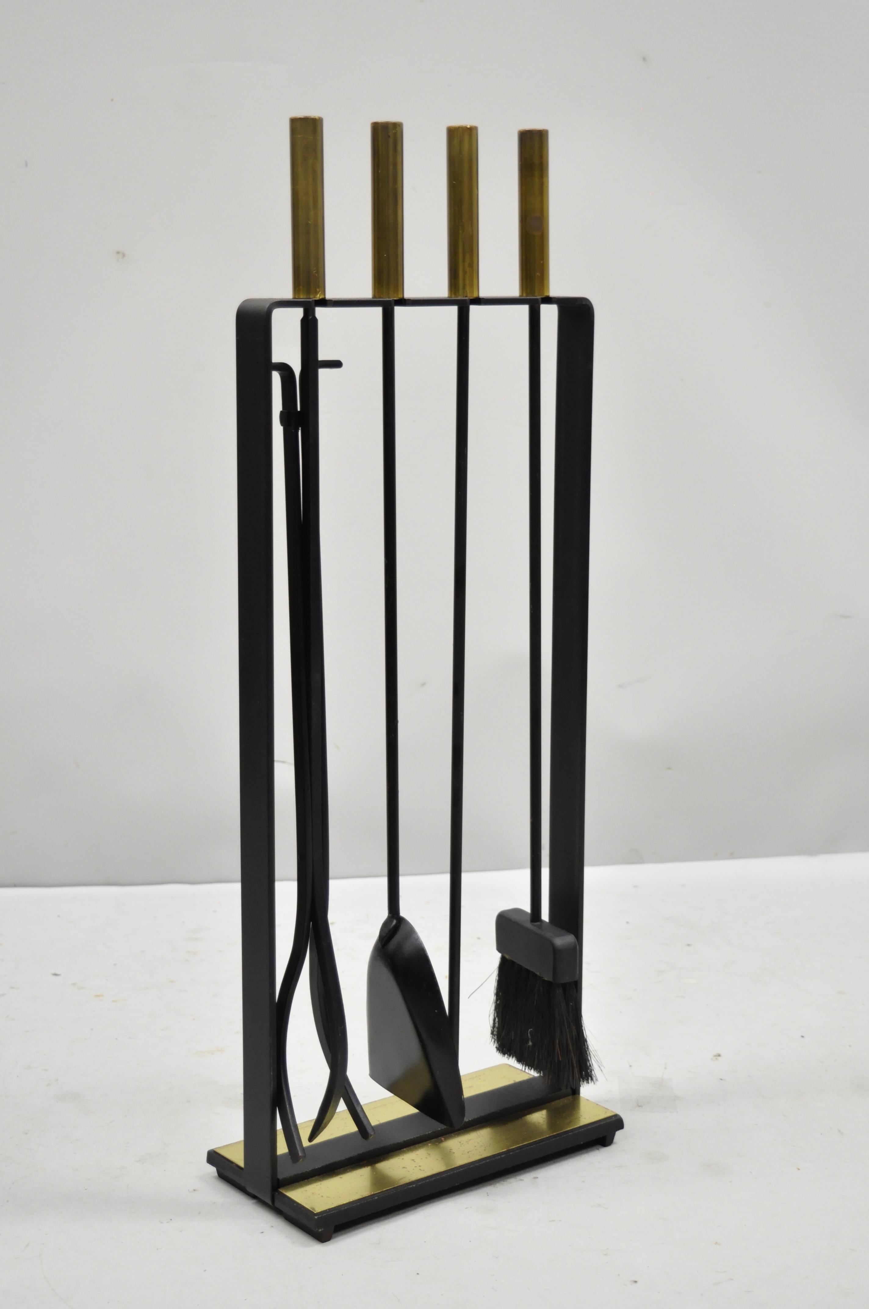 Mid-Century Modern cast iron and brass Minimalist fireplace tool set with stand by Pilgrim. Item features cast iron frame and stand, brass handles and accents, original stamp, very nice vintage item, clean modernist lines, quality American