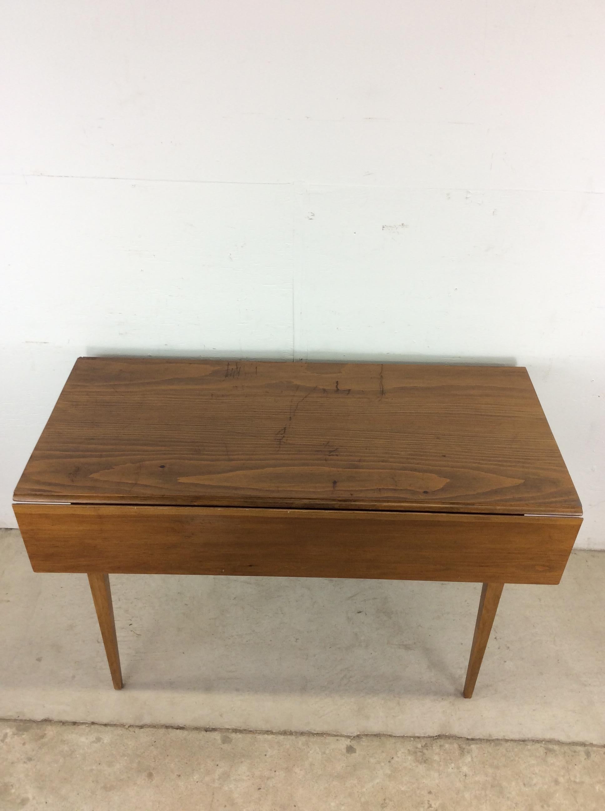 Cette table de salle à manger du milieu du siècle présente une construction en pin doux, un fini moyennement foncé, deux feuilles tombantes et de hauts pieds effilés.

Dimensions : 48w 21d 29h

Notes sur l'état : Le plateau en pin souple présente de