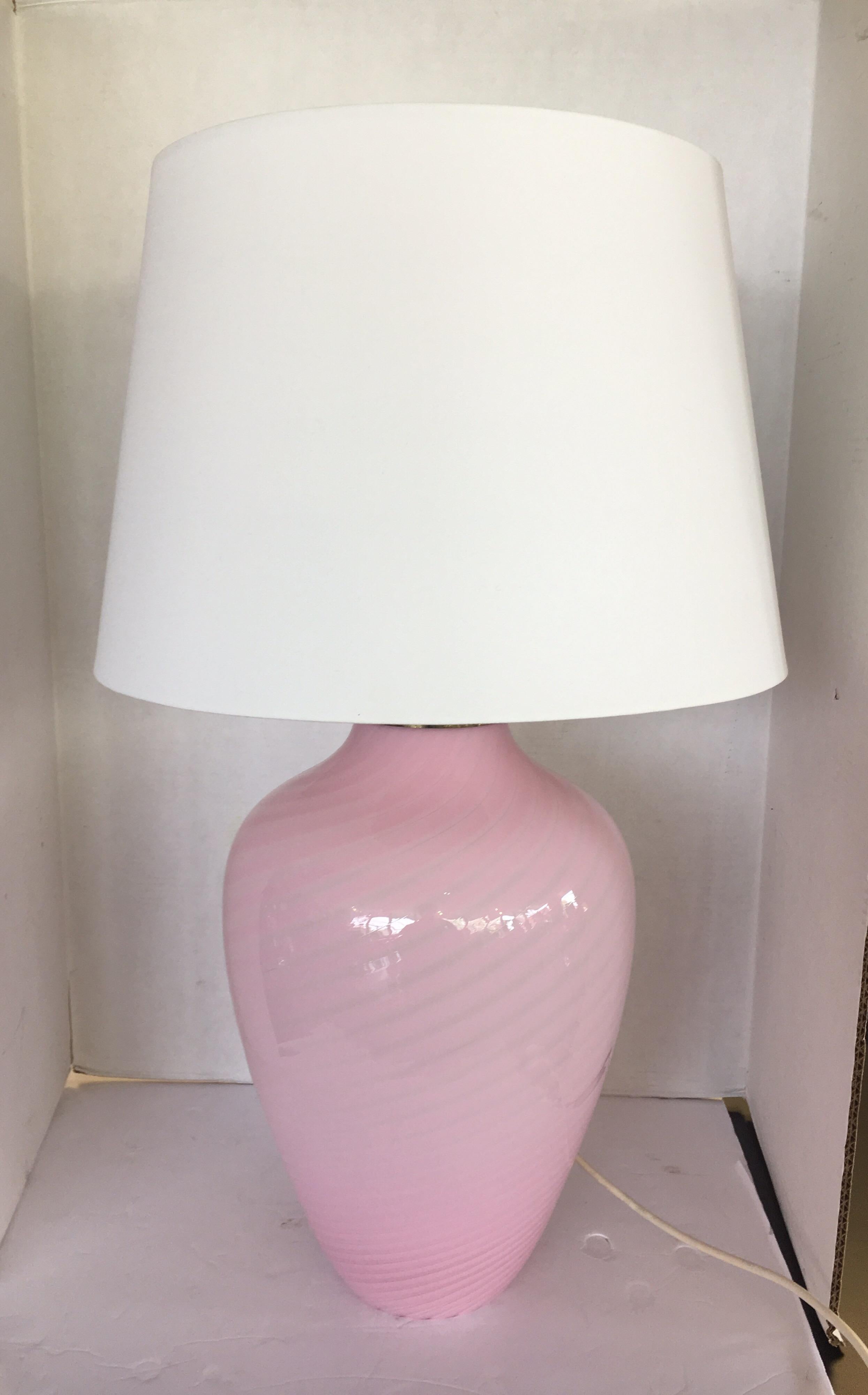 Coveted Murano glass, midcentury pink swirl table lamp, circa 1970s and made in Italy. It is wired for
US and in working order. The lampshade is not original.