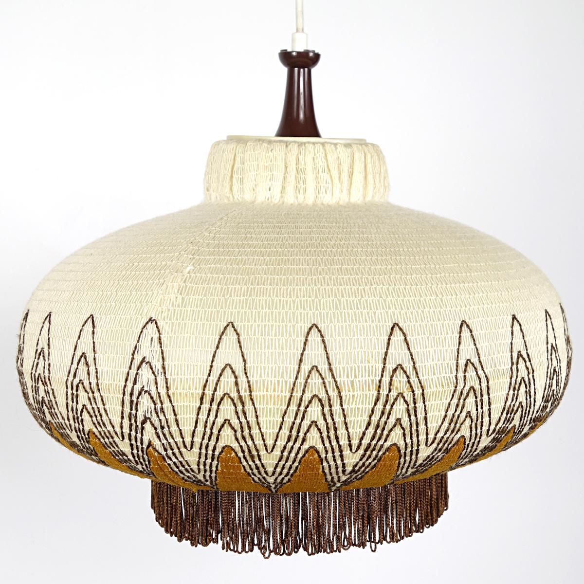 This attractive and radiant pendant has a shade made of plastic that is covered with a crocheted pattern with embroidered accents.
The warm light that is obtained this way creates a great ambiance.
