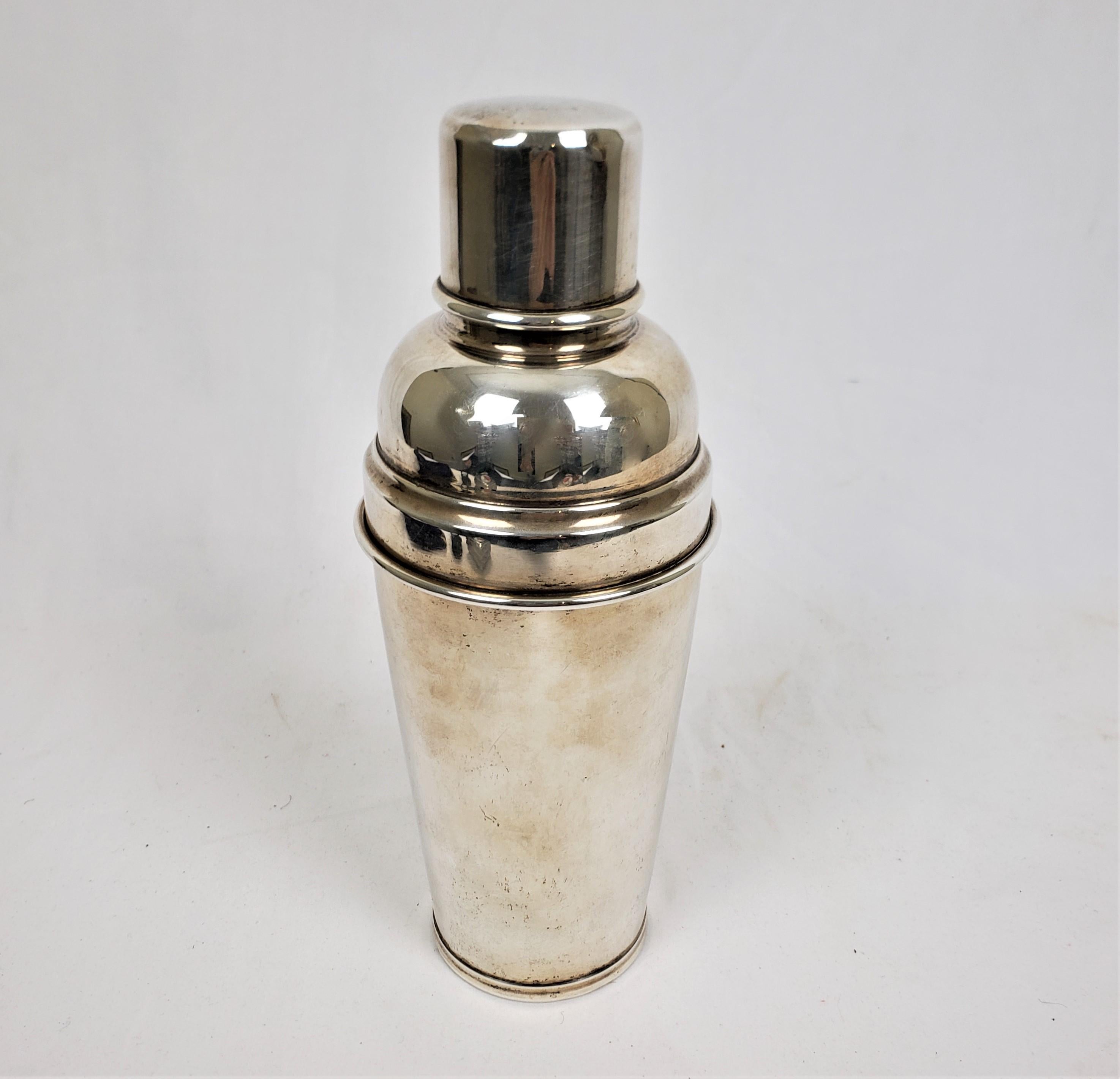 This cocktail shaker is hallmarked by an unknown maker and originated from either Peru or Mexico and dates to approximately 1960 and done in the period Mid-Century Modern style. The cocktail shaker is cmposed of sterling silver and is made up of of