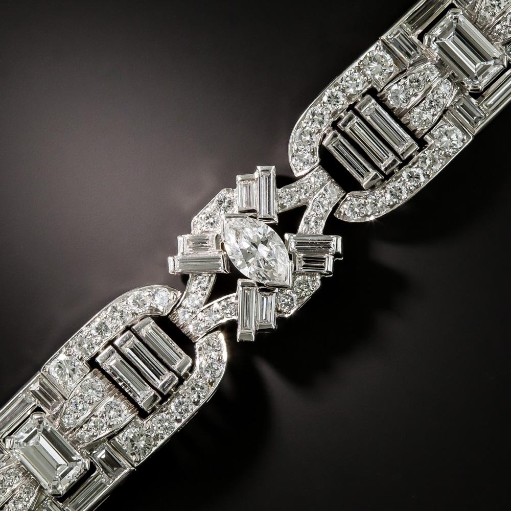 Although exhibiting quintessential Art Deco geometry and architecture, the modern cuts of the icy-white, high-quality platinum diamonds flashing throughout this fabulous wrist bauble date back to the1950s- early 1960s. Evocative of the glamorous