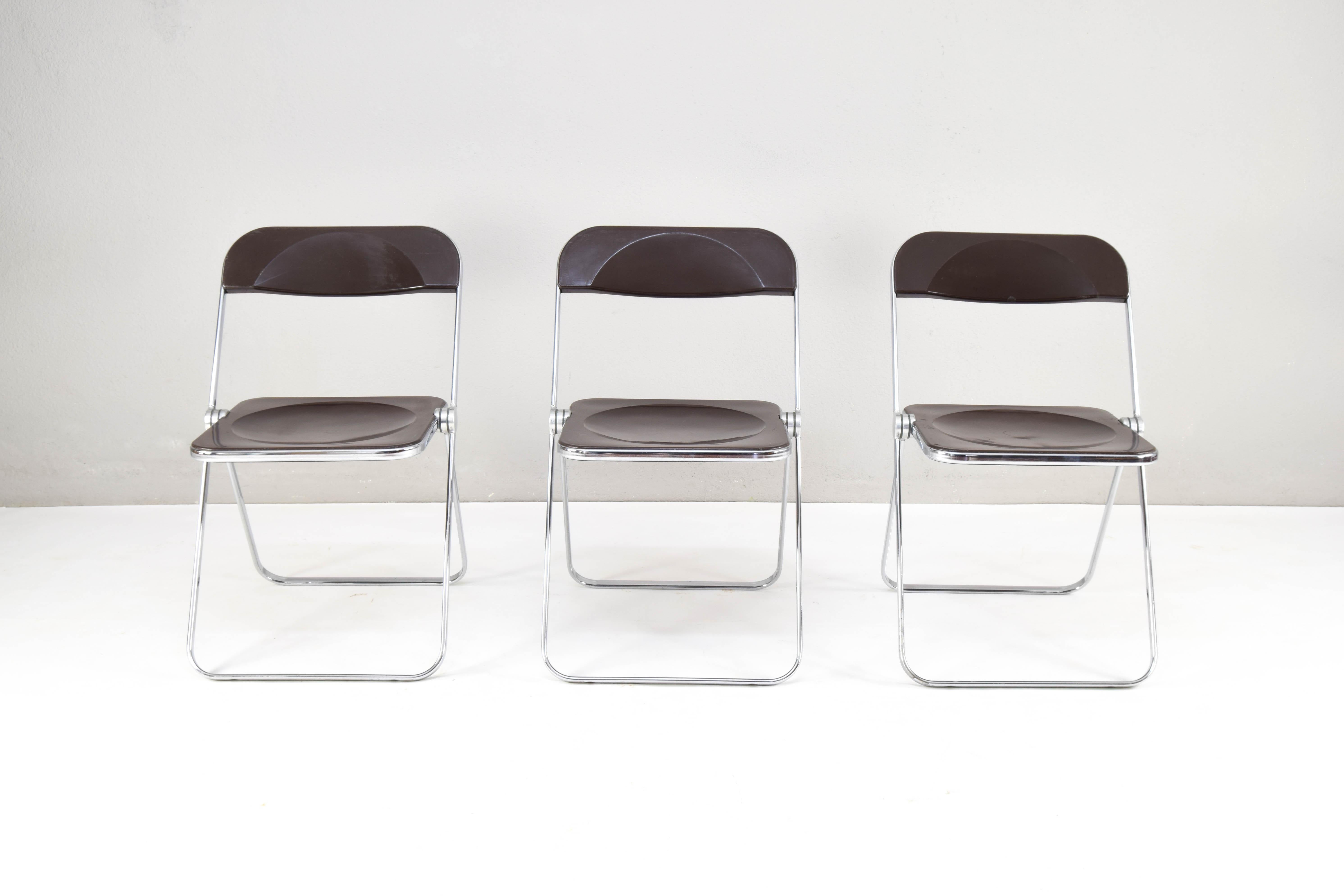 Set of three Plia model folding chairs, designed by Giancarlo Piretti for Castelli in 1960.
Chromed steel structure and brown plexiglass seat.
The chairs have visible areas of wear on the seats and backs and one of them also has wear on the