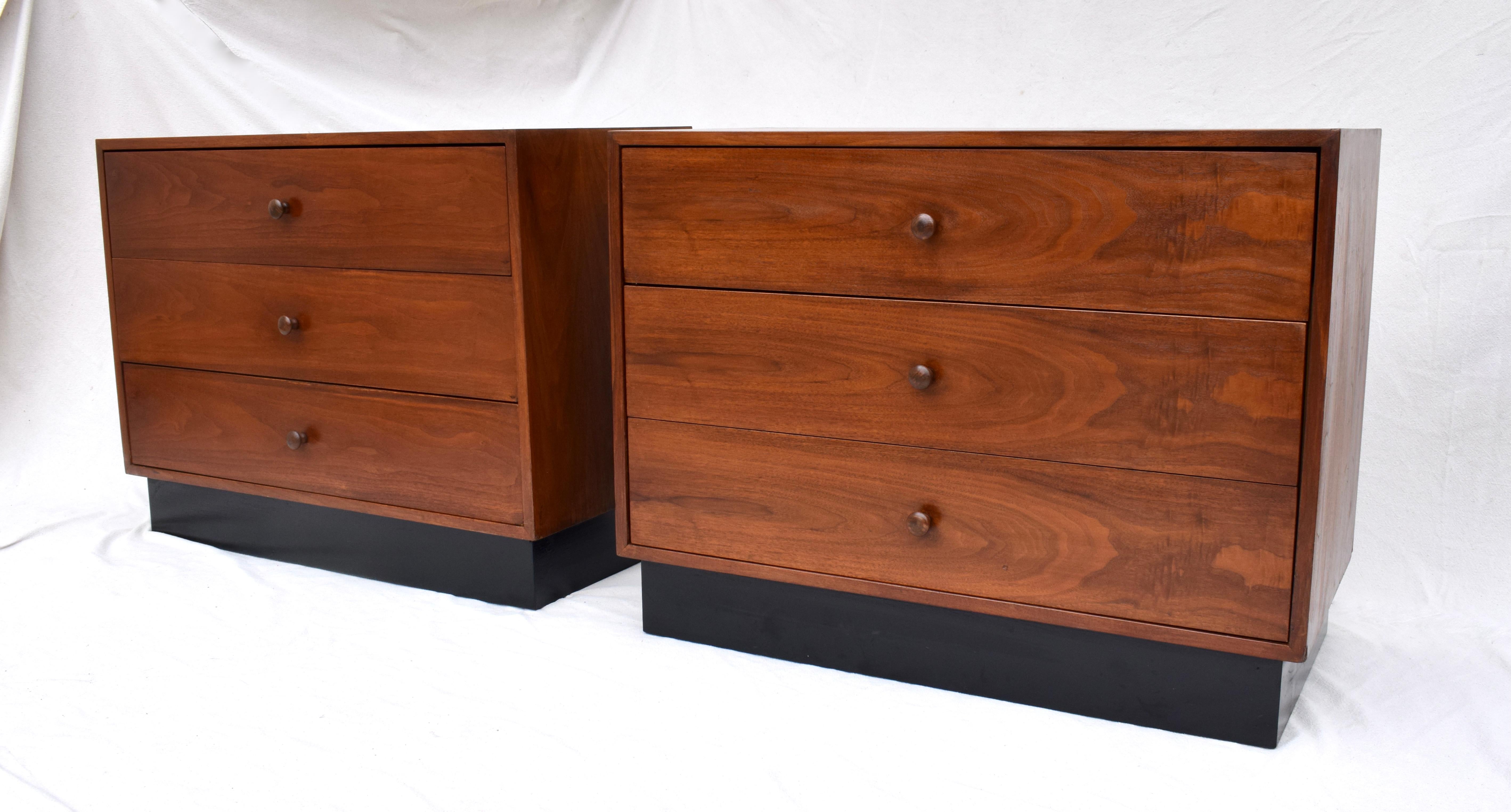 A striking pair of mid 20th century Modern Chests of drawers with impressive fiery walnut grains finished on all four sides. Three drawers each with floating plinth bases.