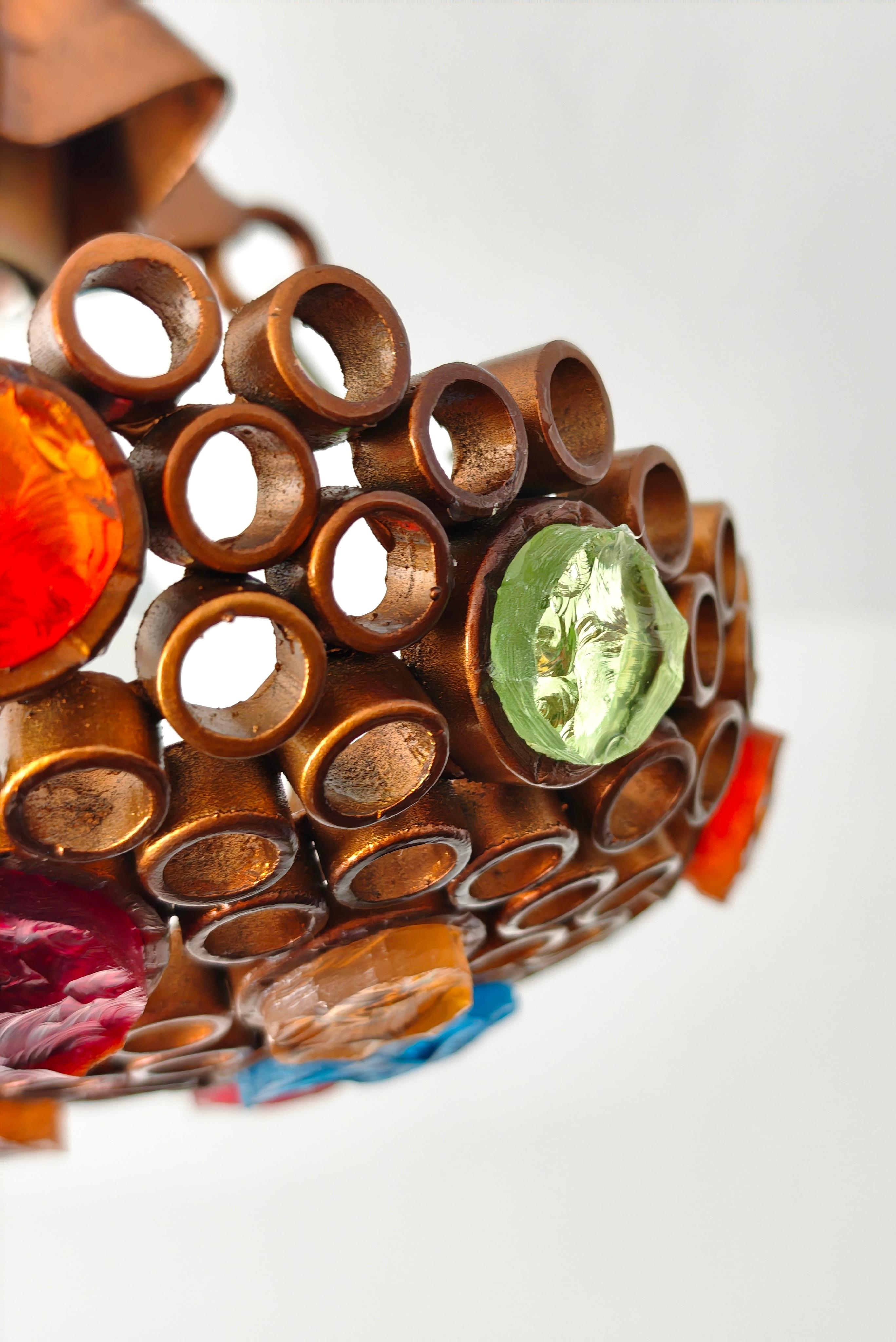 Lustre Poliarte, Italie vers 1970. La lampe rayonne de segments géométriques de verre translucide et coloré, ébréchés à la main, alternant, créant un relief circulaire qui interrompt la lumière, dans les couleurs ambre, rouge, orange, bleu clair,