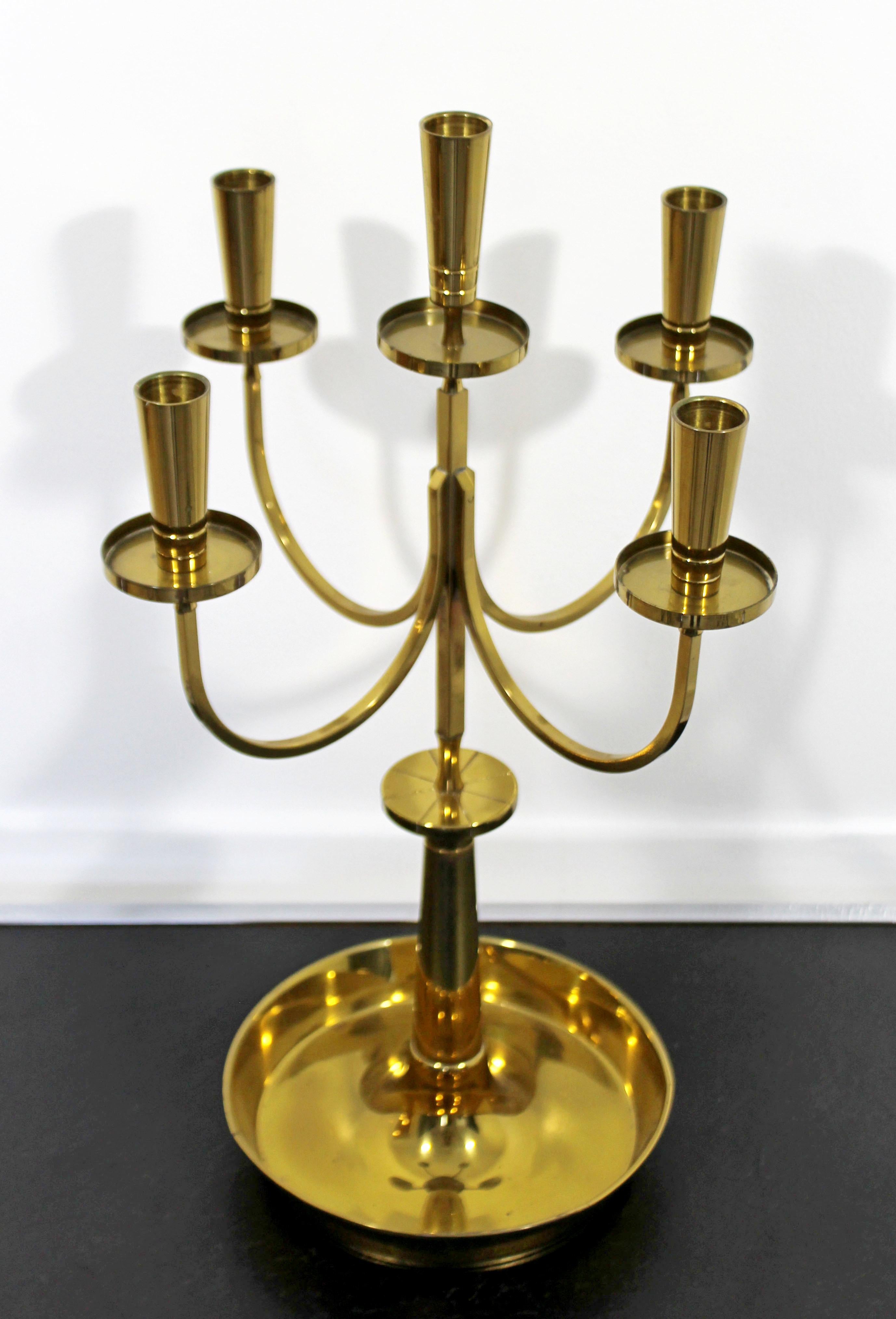 For your consideration is a magnificent, five-arm candelabra, made of polished brass, by Tommi Parzinger for Dorlyn, circa the 1950s. The dimensions are 13
