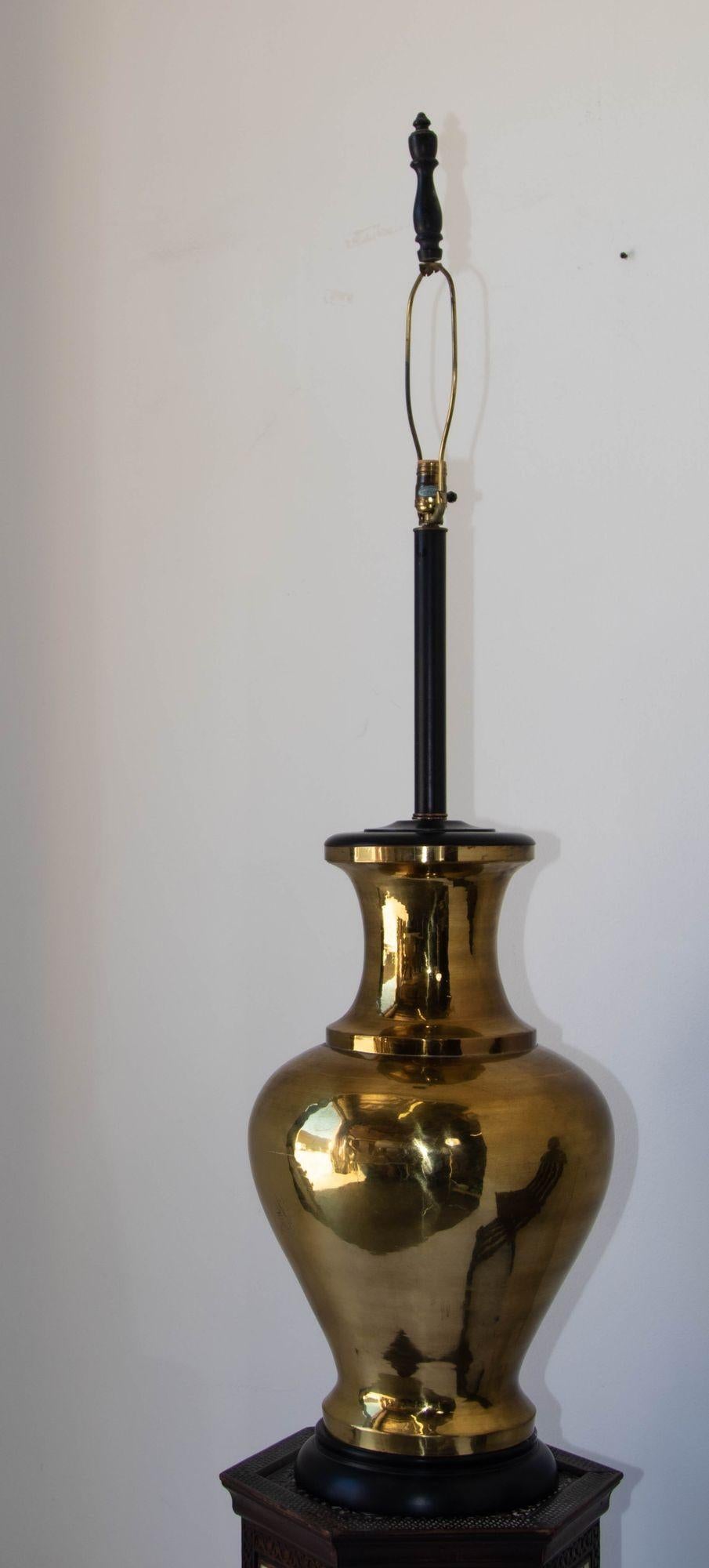 Mid-Century Modern polished brass large scale Chinoiserie brass Urn table lamp 1950's.
A vintage Asian style table lamp with a solid urn in polished brass and original oversized shade.
Hollywood Regency monumental table lamp and impeccably