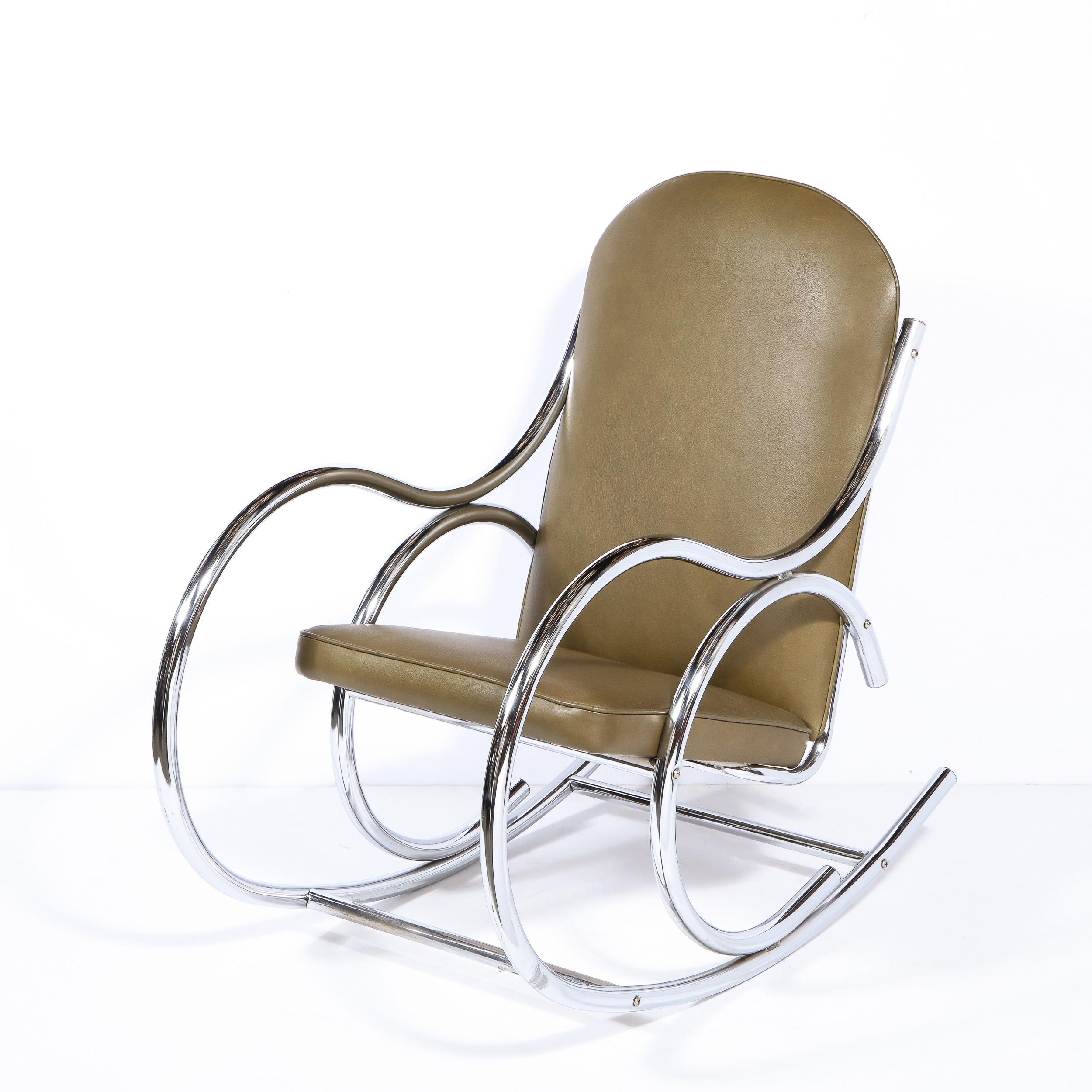 This sophisticated Mid-Century Modern rocking chair was realized in the United States circa 1970. It offers a streamlined demilune form in polished tubular chrome that creates both the arms and the feet. Additionally, there is a matching detail- of