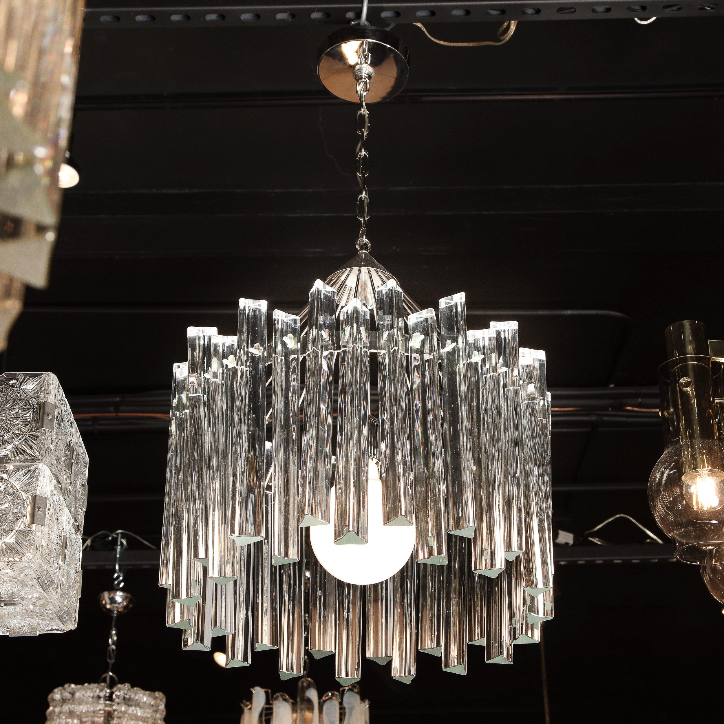 This stunning Mid-Century Modern chandelier was realized in Murano, Italy circa 1970. It features a circular open form frame in lustrous polished chrome. with a wealth of translucent handblown Murano triedre crystals suspended around the perimeter.