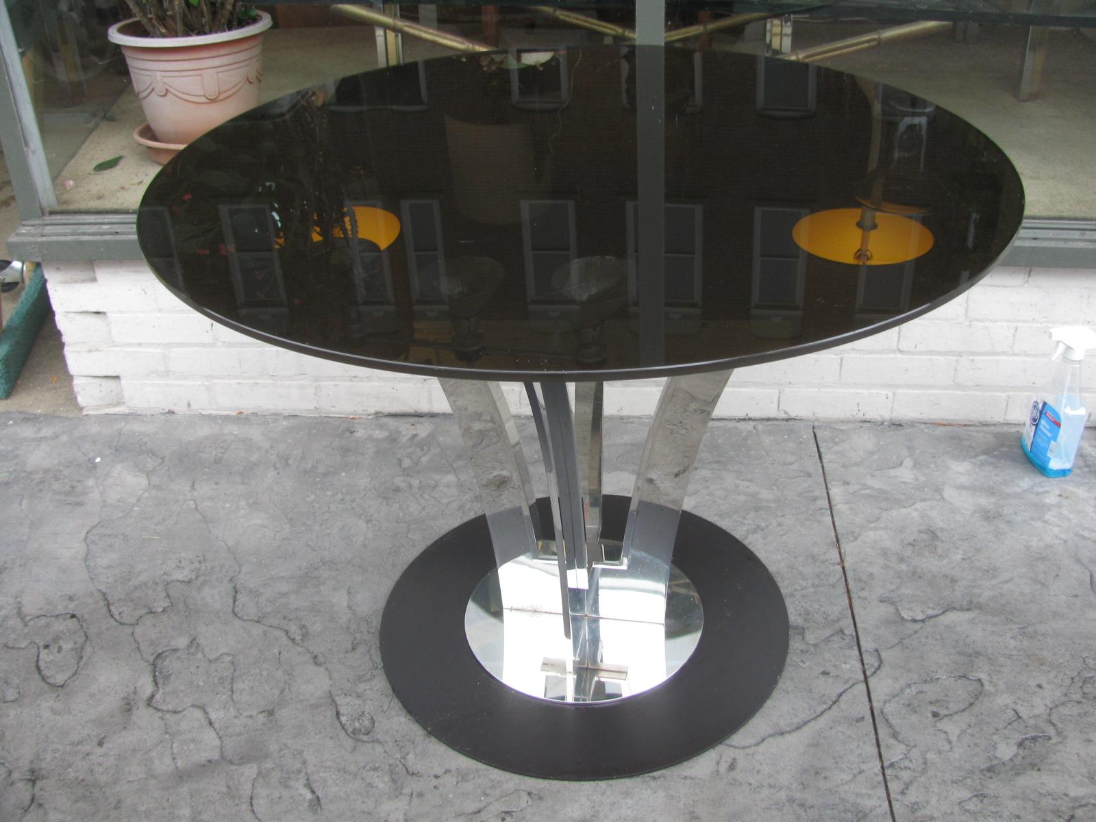 Fabulous and heavy polished steel table with a flared arch support. Measures: 38inch smoked glass top. Came from a Roberto Cavalli flagship store in Manhattan, NYC. Two are available. Price is for each. Top can be replaced with a marble or stone top