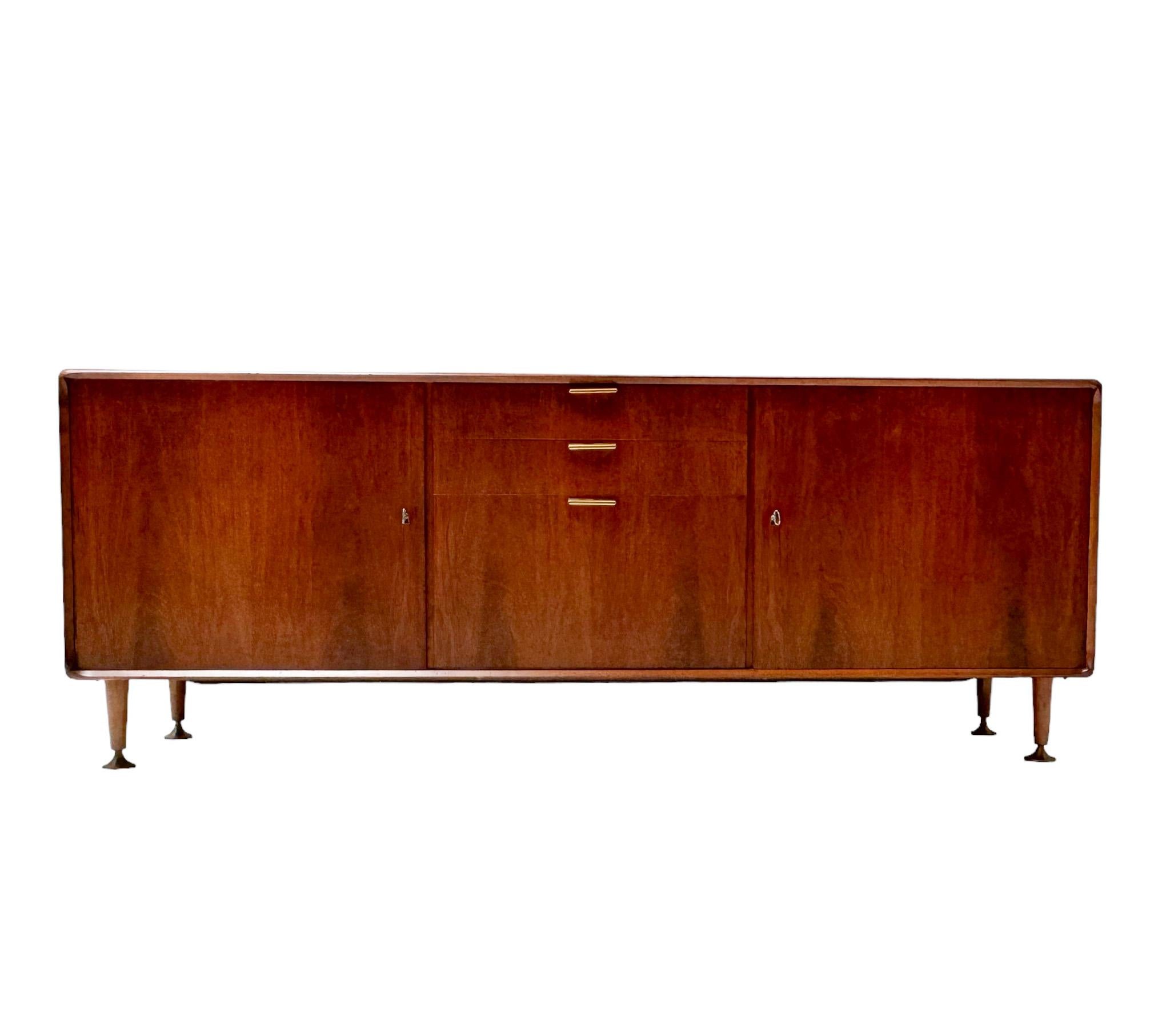 Magnificent and rare Mid-Century Modern Poly-Z credenza or sideboard.
Design by A.A. Patijn for Zijlstra Joure.
Striking Dutch design from the 1950s.
Solid walnut and original walnut veneer base with original brass handles on the two drawers and