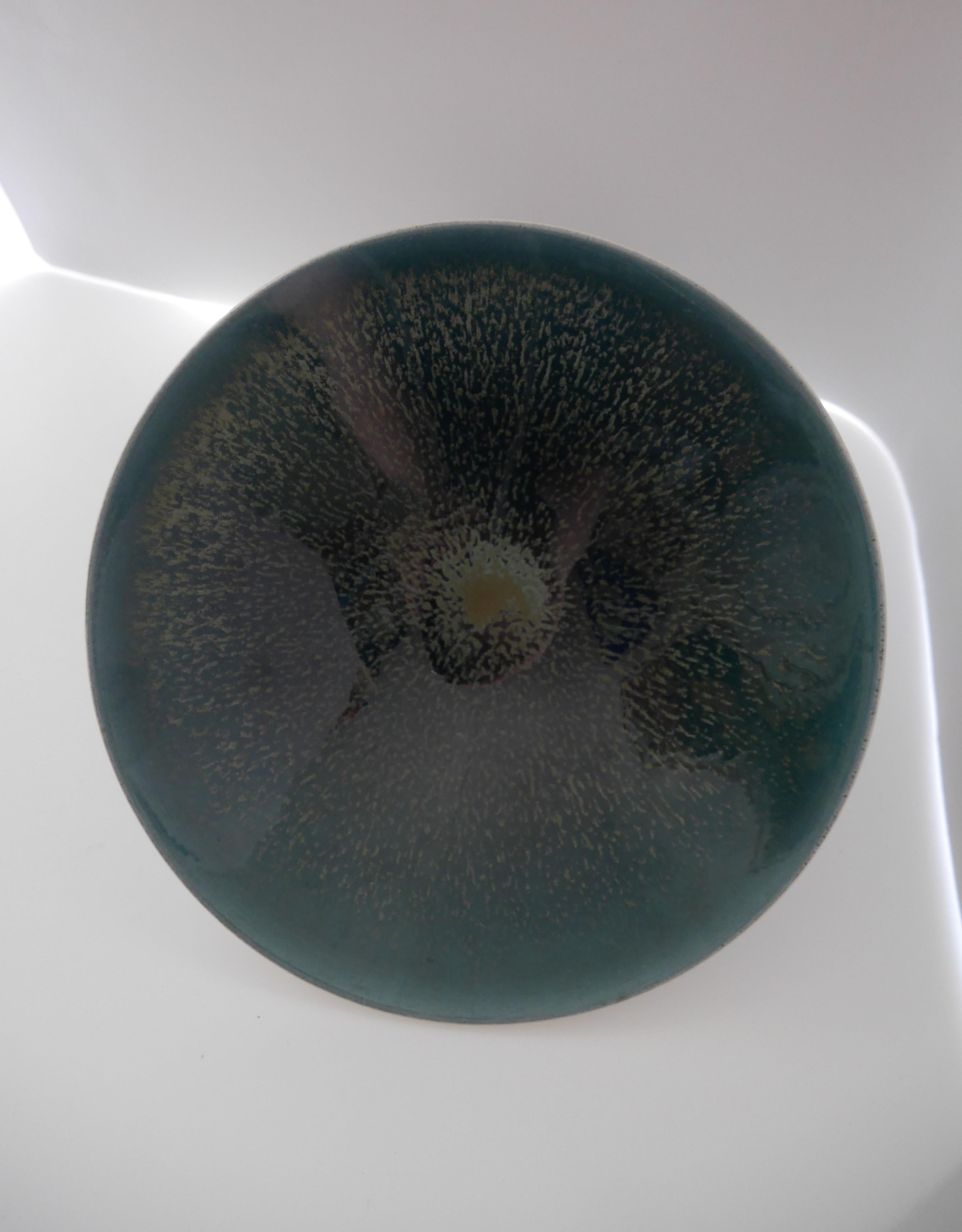 A  fantastic small mid-century modern Poole studio pottery bowl, England. This is a rare item for the company due to the special color and glazing. This ceramic bowl has a fantastic glazing in some fantastic colors ranging from green to blue to