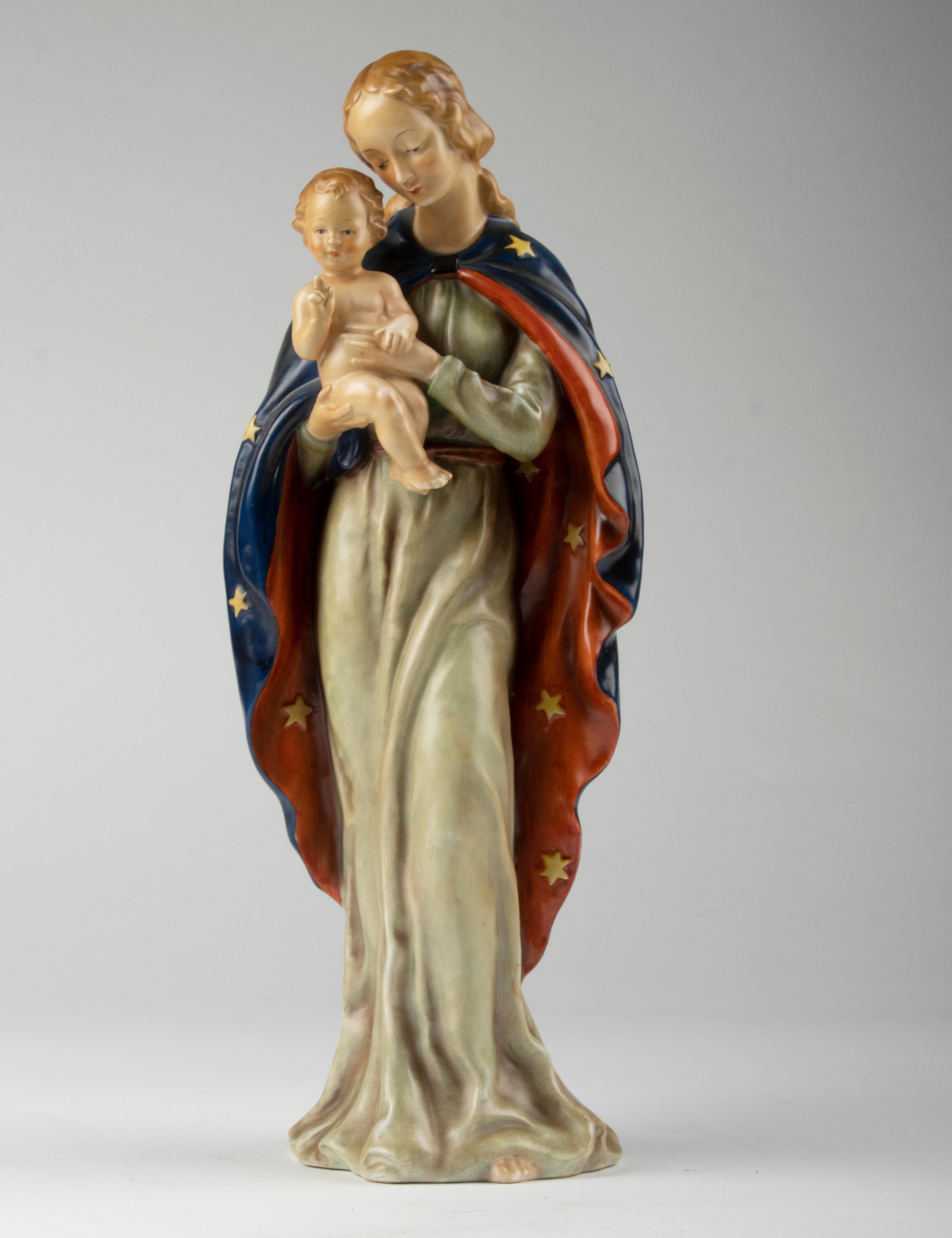 Beautiful porcelain statue of Mary with baby Jesus on her arm. The statue is hand painted in beautiful colors. The statue is marked on the bottom with the Bee Mark by Goebel. The statue is in very good condition.