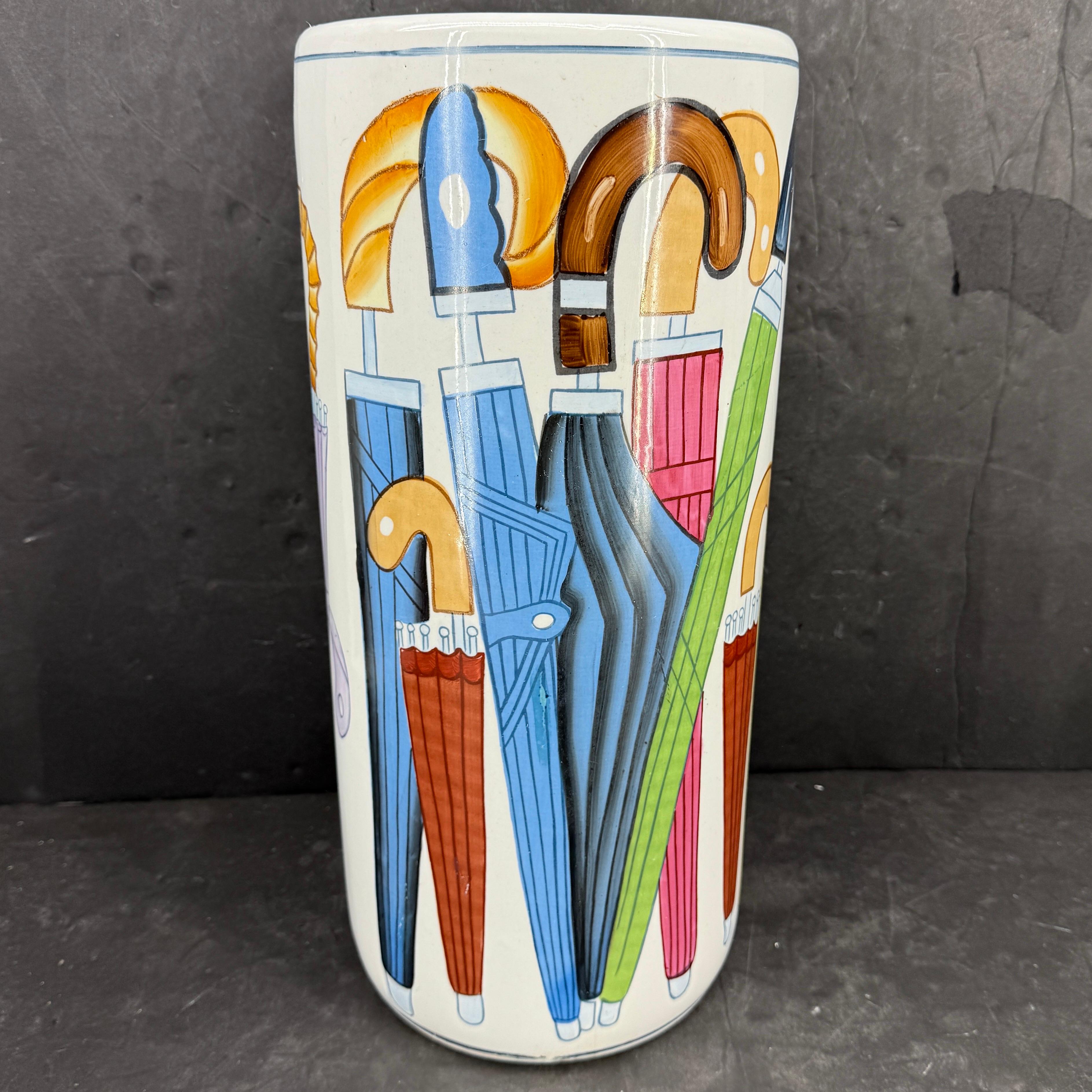 Dieser elegante und charmante Schirmständer im Fornasetti-Stil stammt wahrscheinlich aus Italien aus den 1950-60er Jahren.
Der Ständer besteht aus weißem Porzellan als Grundfarbe und ist mit blauen, rosa, grünen, gelben und roten Schirmen farbenfroh