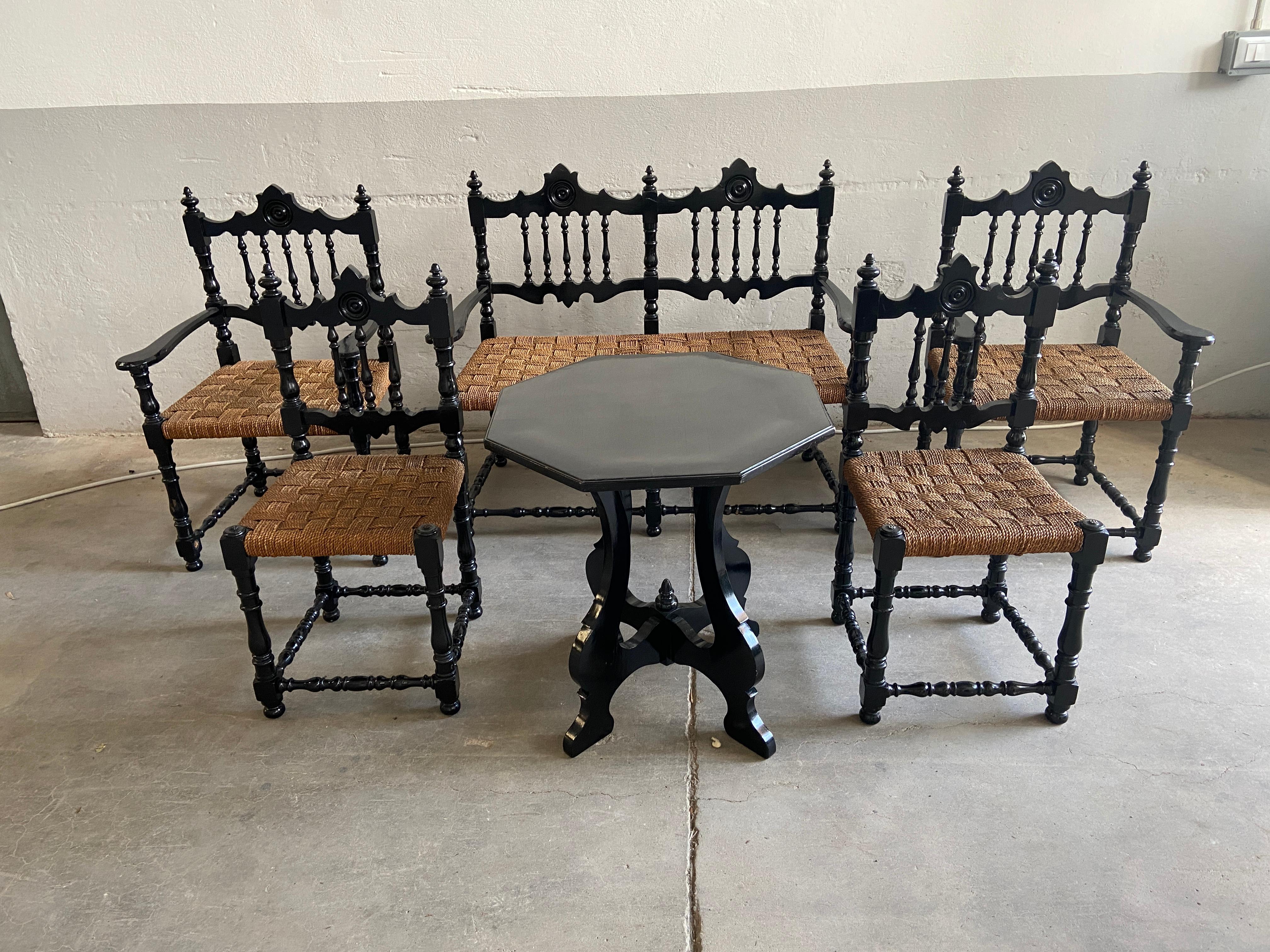 Mid-Century Modern Portuguese living room set in ebonized wood and straw stuffing from 1960s. 
The set consists of a little table, two armchairs, two chairs and one sofa.
Measurements:
- Table cm.80 x 80 x H 74 
- Sofa cm.112 x 54 x H 91 (seat