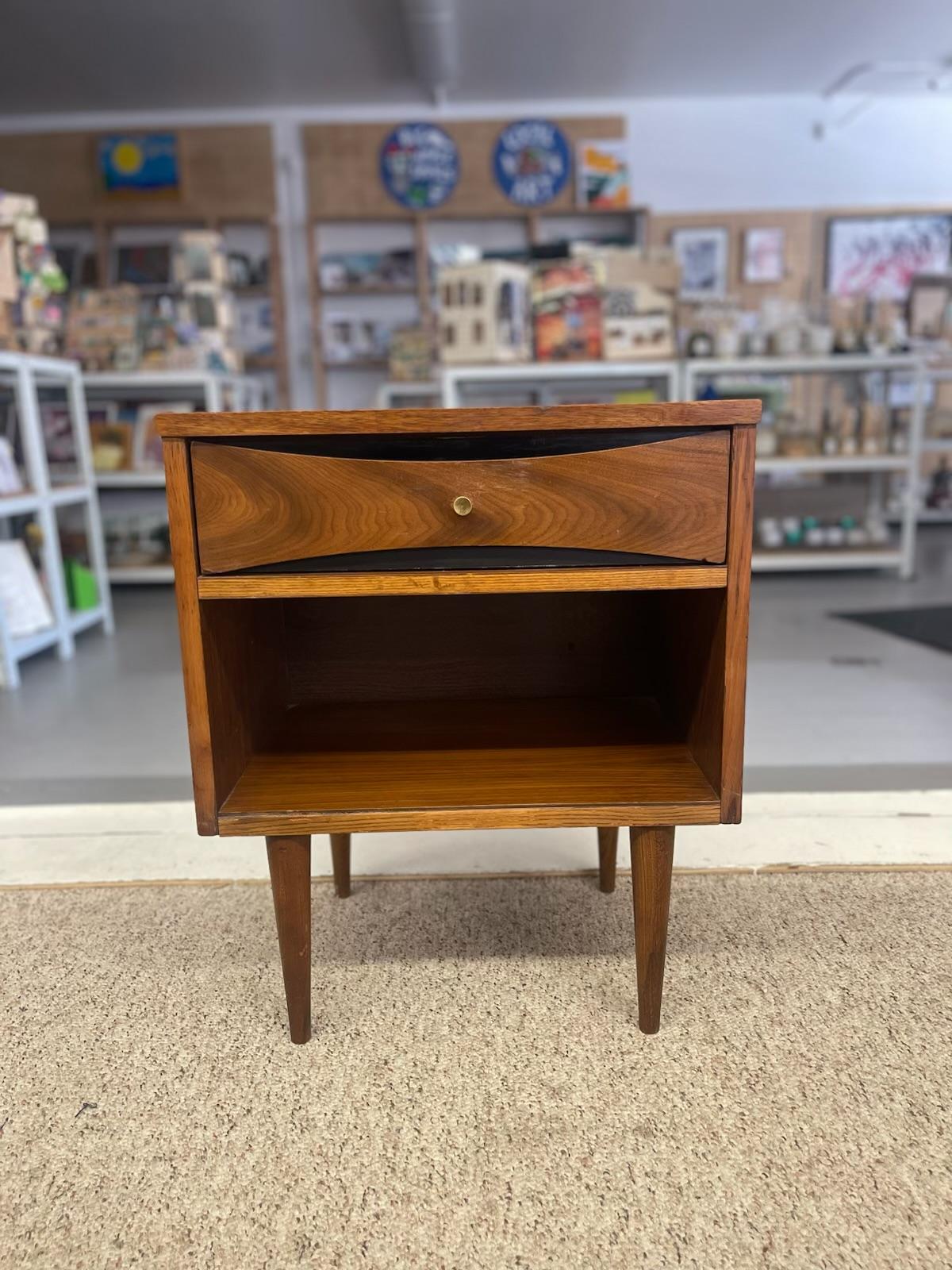 Raffinato esempio di design moderno di metà secolo, questo comodino vintage in noce probabilmente combina una forma scultorea con una funzione pratica. La cassa è realizzata in caldo legno di noce, con ricche venature su tutte le superfici visibili.