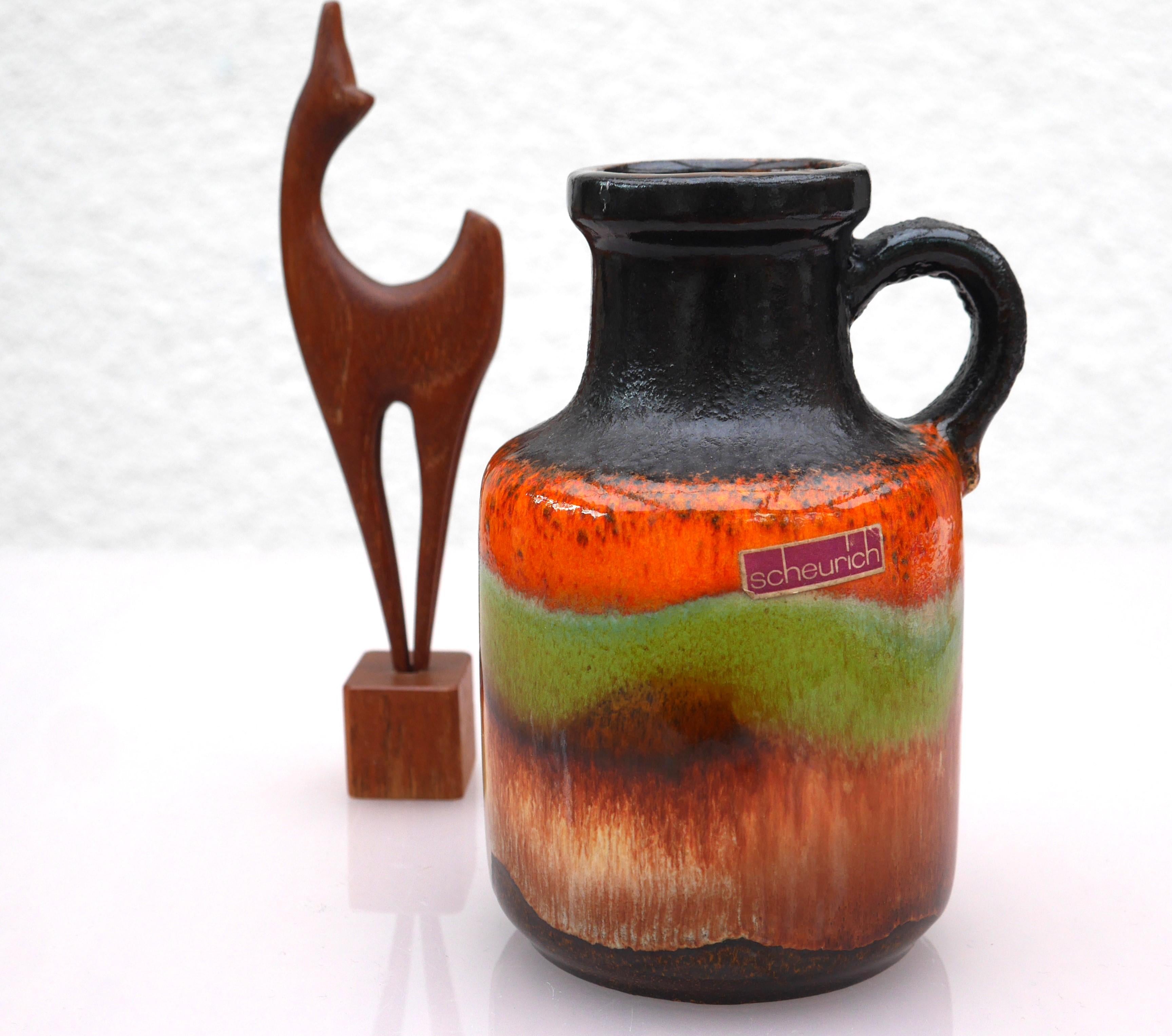 A one of a kind vintage fat lava ceramic vase from Scheurich. This vase is iconic in the shape and pattern as well as glazing with a dark brown nuance and red, orange and green details. This vase is very much of its time, yet still has a modern