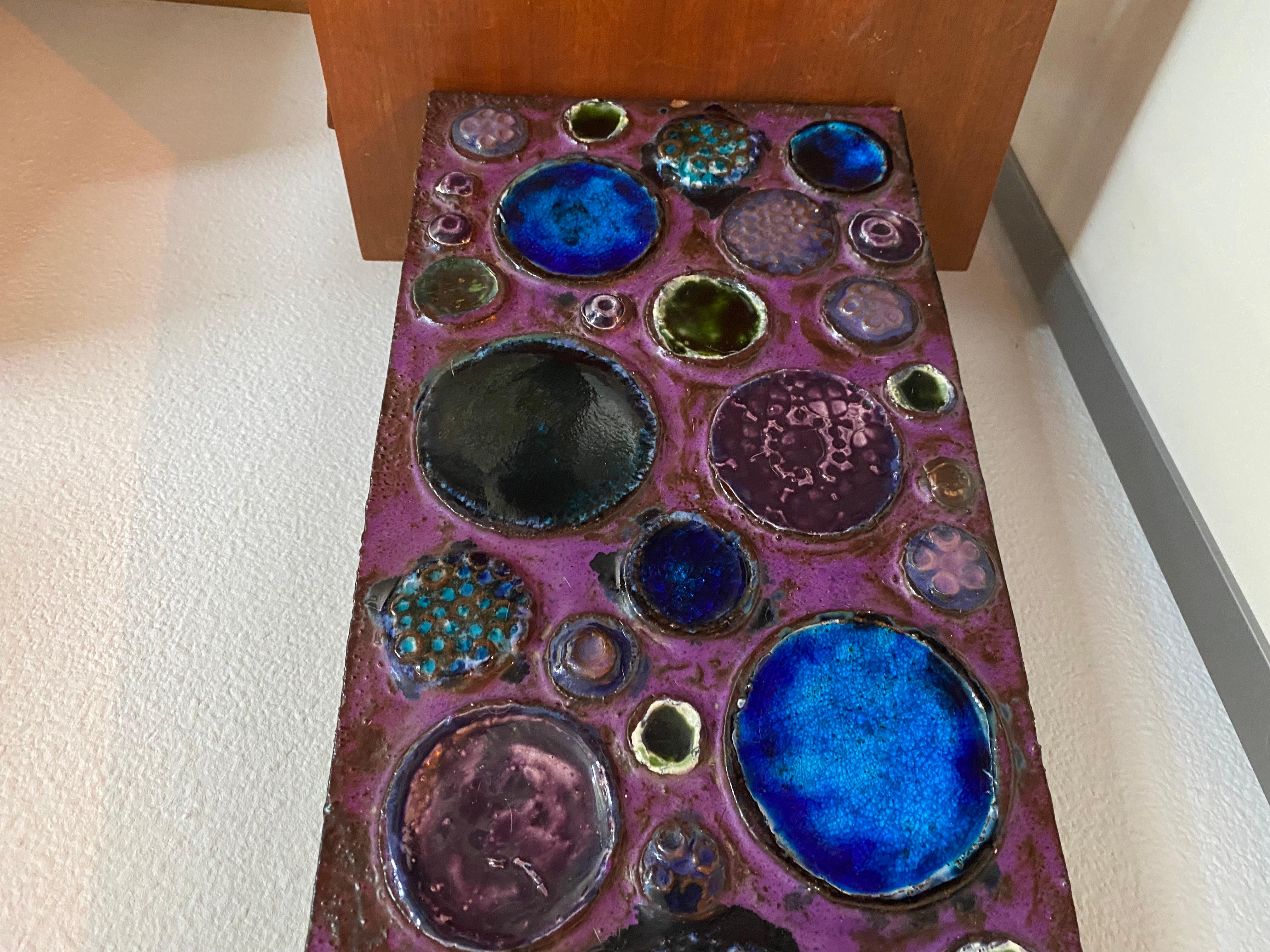 Asombrosa y rara placa mural abstracta fabricada por Ceramano Alemania en los años sesenta.
Se trata de un enorme y pesado revestimiento cerámico, decoración Urania.
La placa es una combinación de  colores morado, azul y verde en diferentes esmaltes