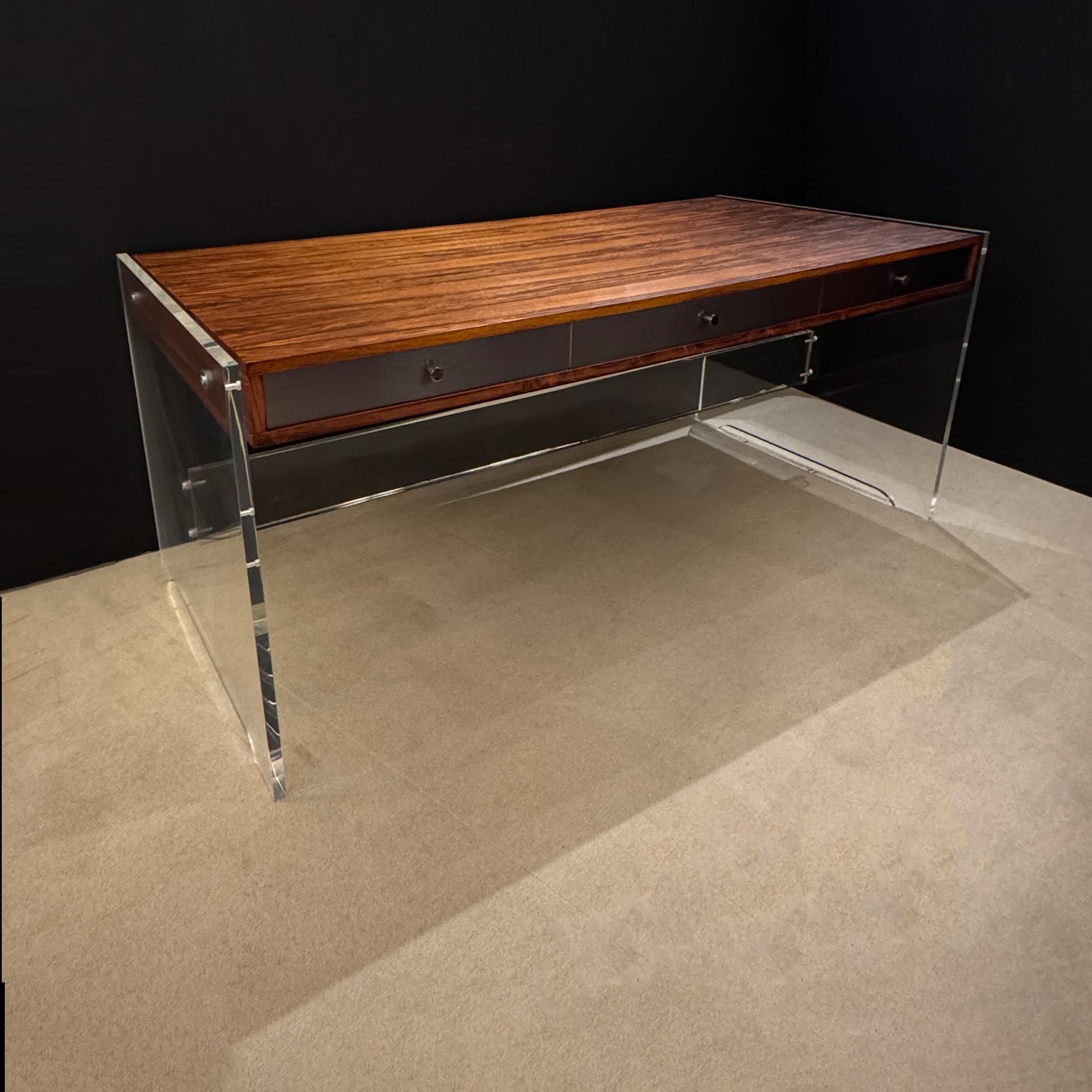 Questa splendida scrivania, progettata dal rinomato designer danese Poul Norreklit, presenta un mix perfetto di estetica moderna di metà secolo e artigianato innovativo. Caratterizzata da un'elegante combinazione di legno impiallacciato, plexiglass