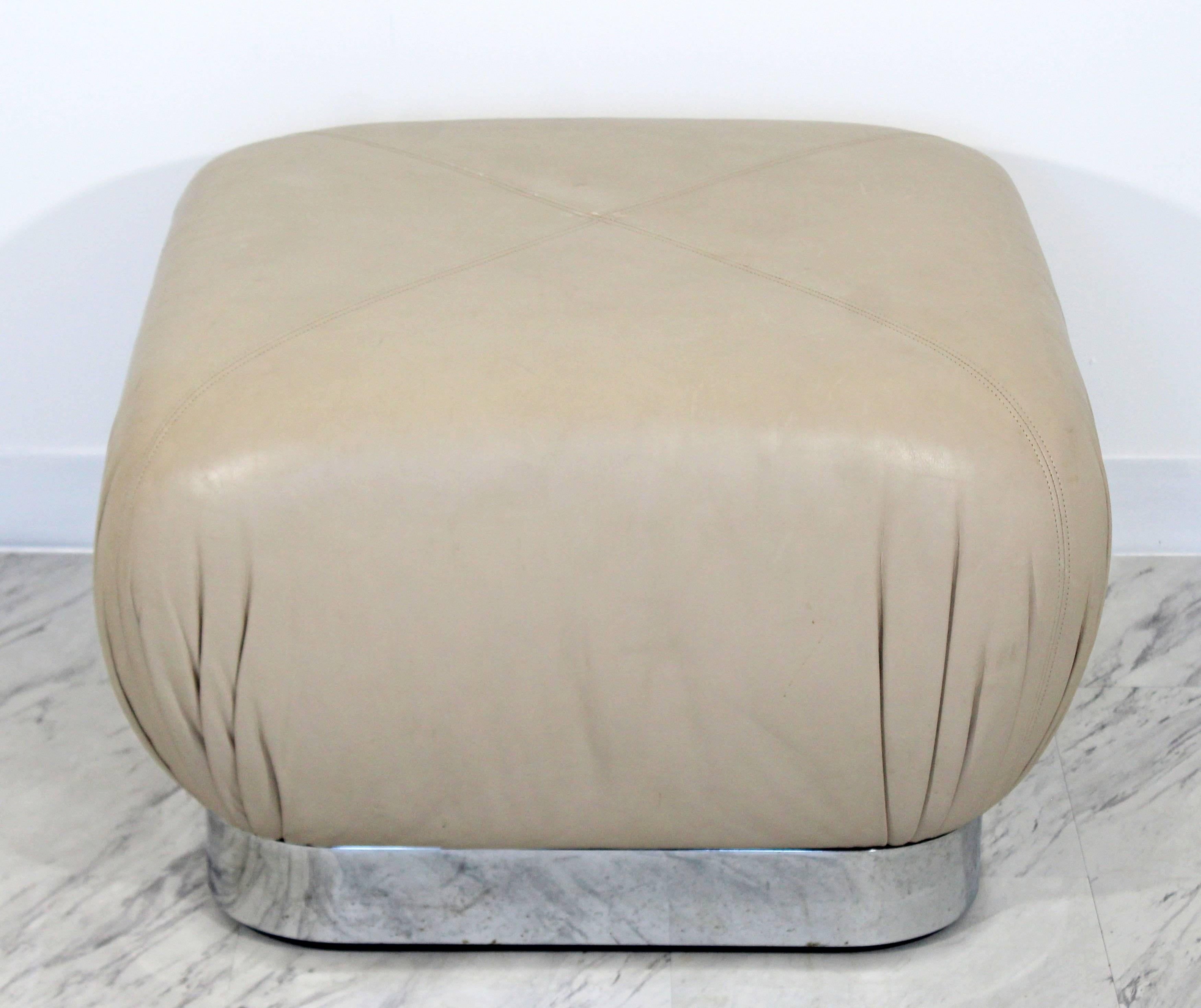 For your consideration is a gorgeous, beige leather and chrome ottoman, on wheels, by Preview Furniture, circa the 1970s, in the style of Karl Springer. In excellent condition. The dimensions are 24