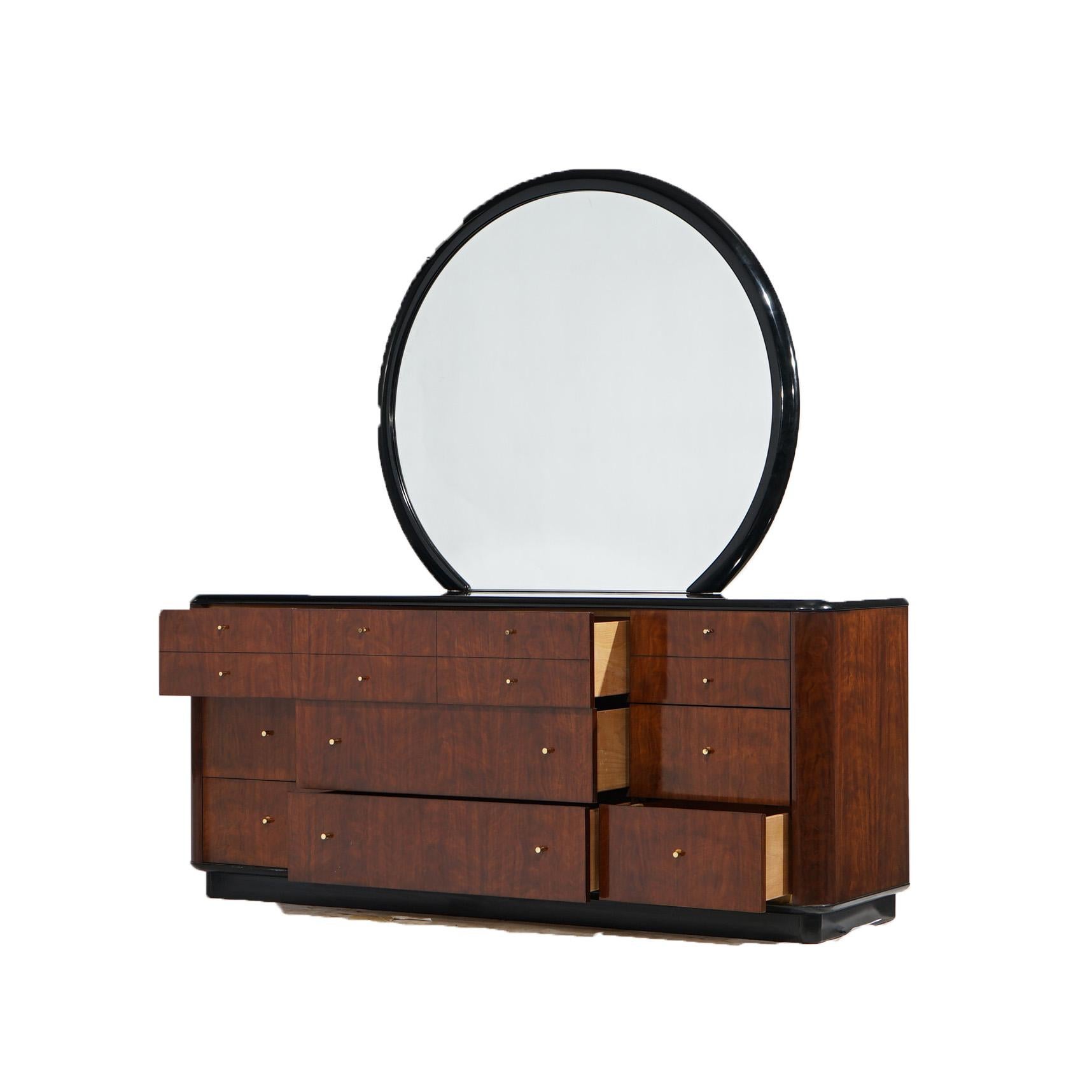 A Mid Century Modern dresser by Drexel in the Profiles line offers mahogany construction with circular mirror surmounting case having ebonized top over case with drawers of various sizes, raised on an ebonized base, maker mark as photographed, 20th
