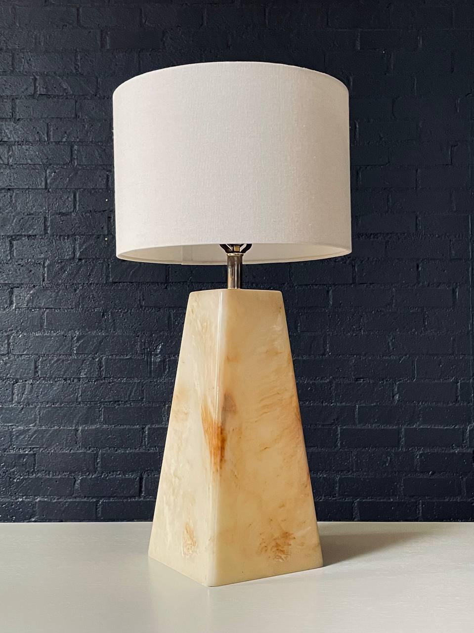 Condition: Original Rewiring, New Linen Shade 
Materials: Resin Base, New Custom Linen Shade

This striking Mid-Century Modern pyramid-style table lamp, crafted in the United States circa 1960s, features a sculptural resin base that glows warmly