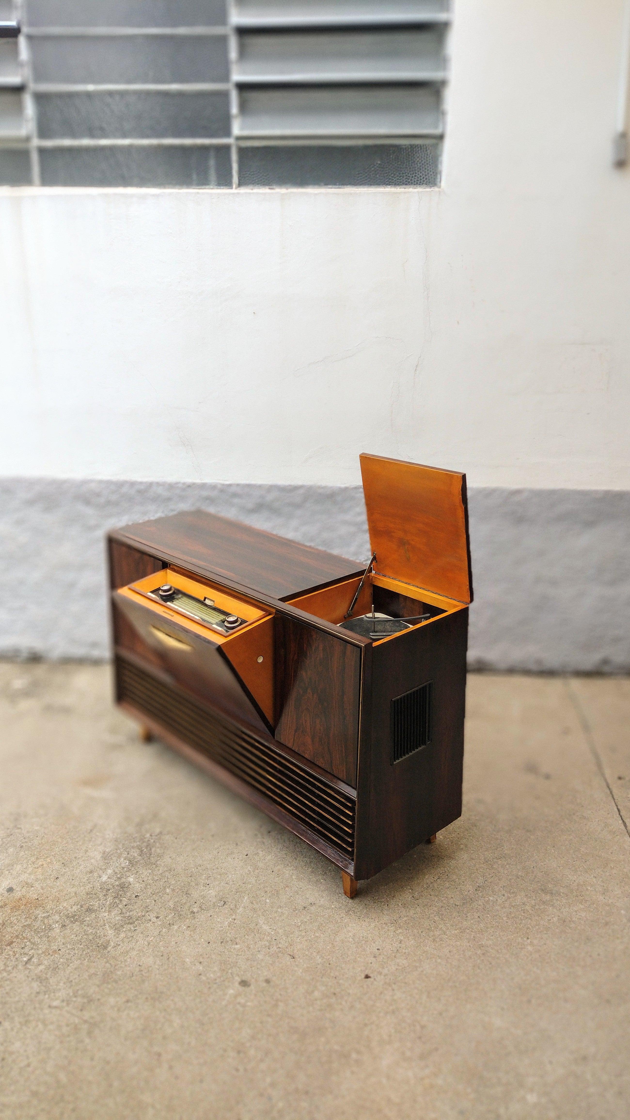 Mid-Century Modern Telefunken Victrola/Radio in Rosewood Veneer. Piece does not work, We recommend decorative use. In Good Condition.

Approximate measures:
Height: 90cm / Width: 140cm / Depth: 44cm

Main wear details:
-Wooden structure has