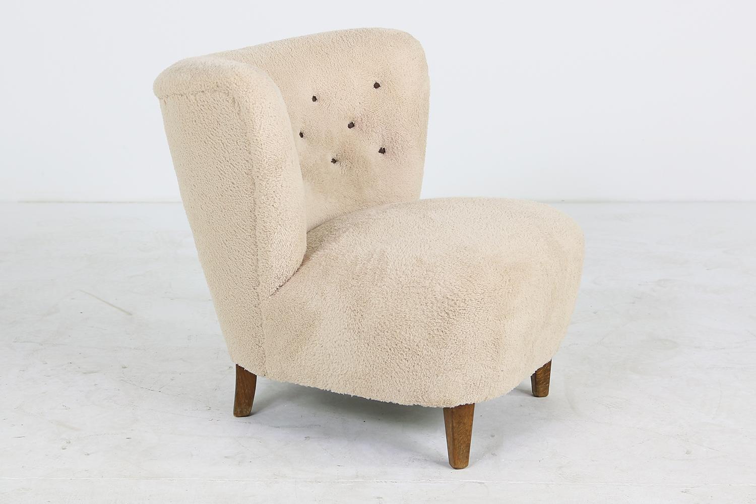 Beautiful 1950s lounge chair by Gösta Jonsson, Jönköping Sweden, very rare piece, stained beechwood legs, new upholstery and covered with a teddy faux fur fabric, super soft cotton fur, with beautiful dark brown leather buttons, restored. This rare