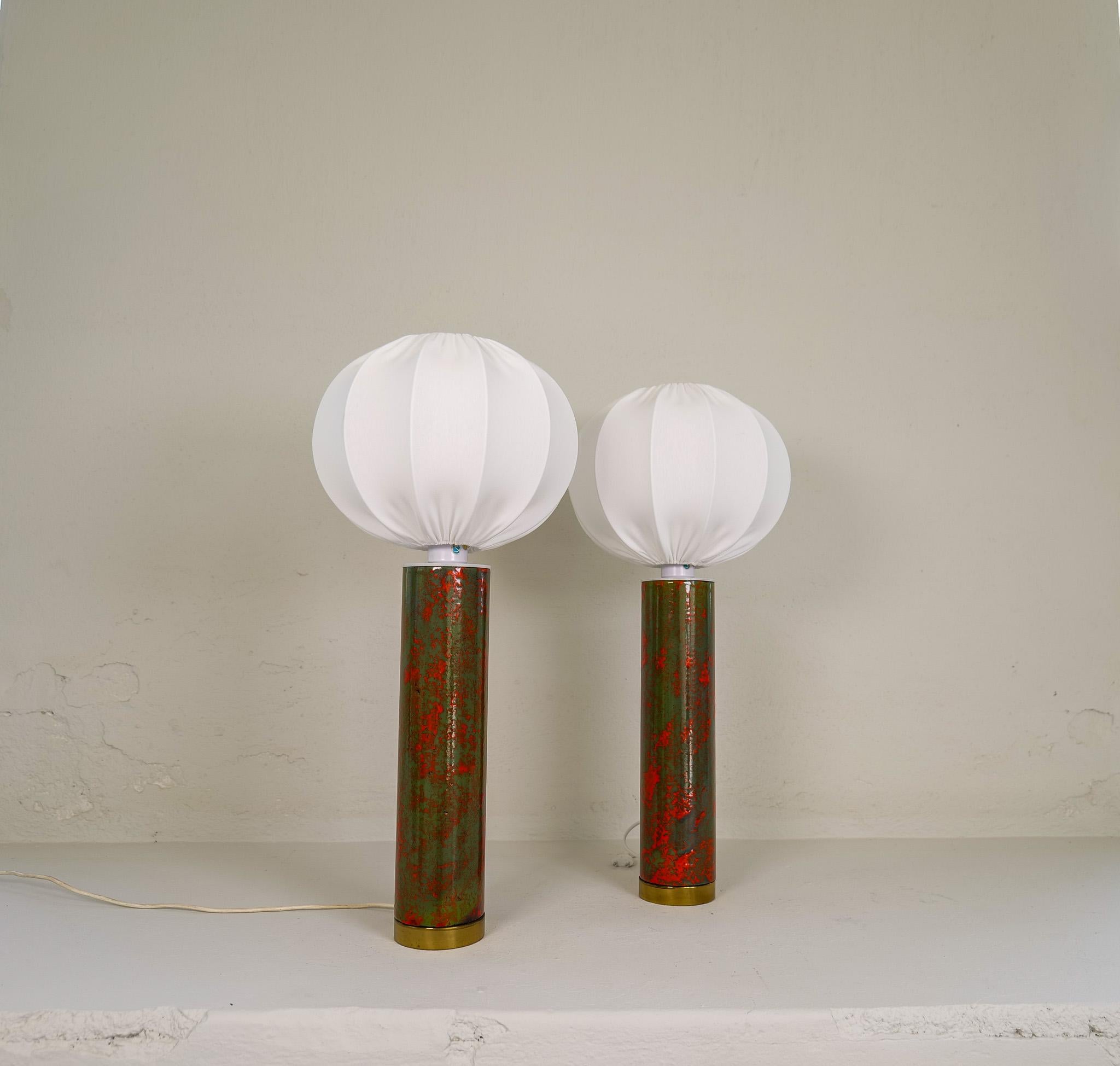This set of rare and large table lamps was produced in Sweden during the late 1960 early 1970s. 
Made in ceramic with a wonderful green / red glaze combined with a brass base bottom. 
New shades made in Sweden are included. 

Very good vintage