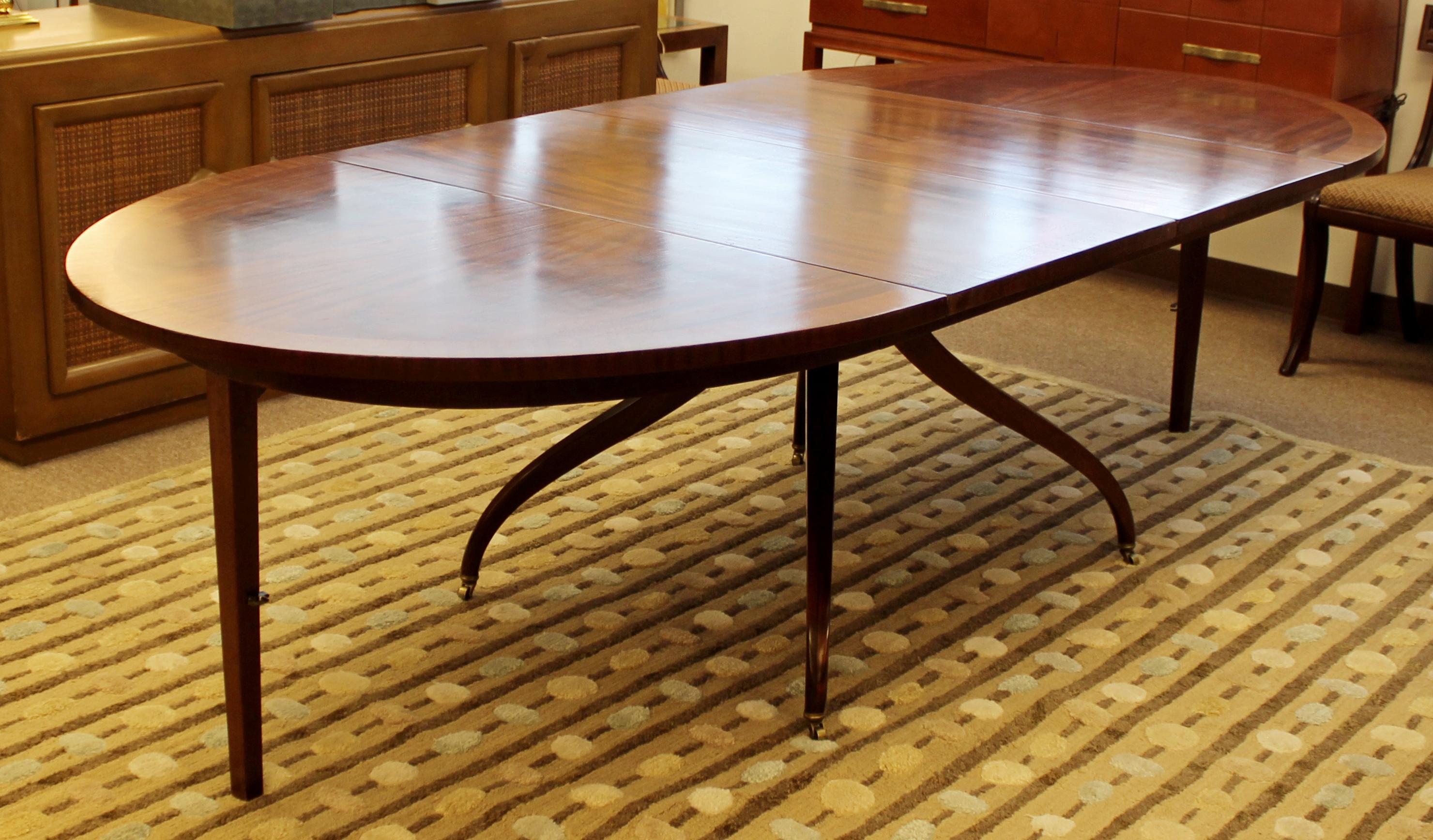For your consideration is a phenomenal oval drop leaf dining table, made of two-tone wood with brass accents on the feet, with two leaves and legs that drop down or fold up, by Edward Wormley for Dunbar, circa 1960s. In good condition. The