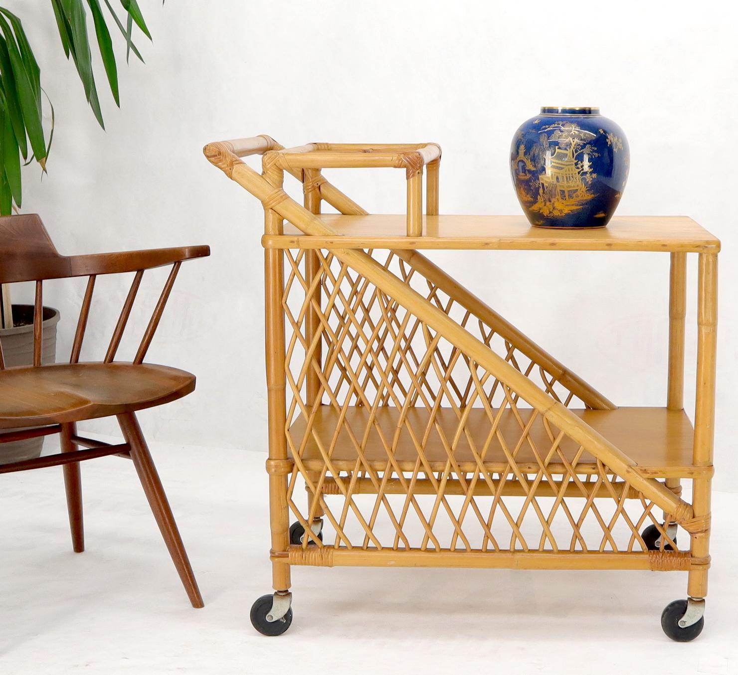 Mid-century modern rattan and bamboo two tier are serving cart liquor bar on wheels.