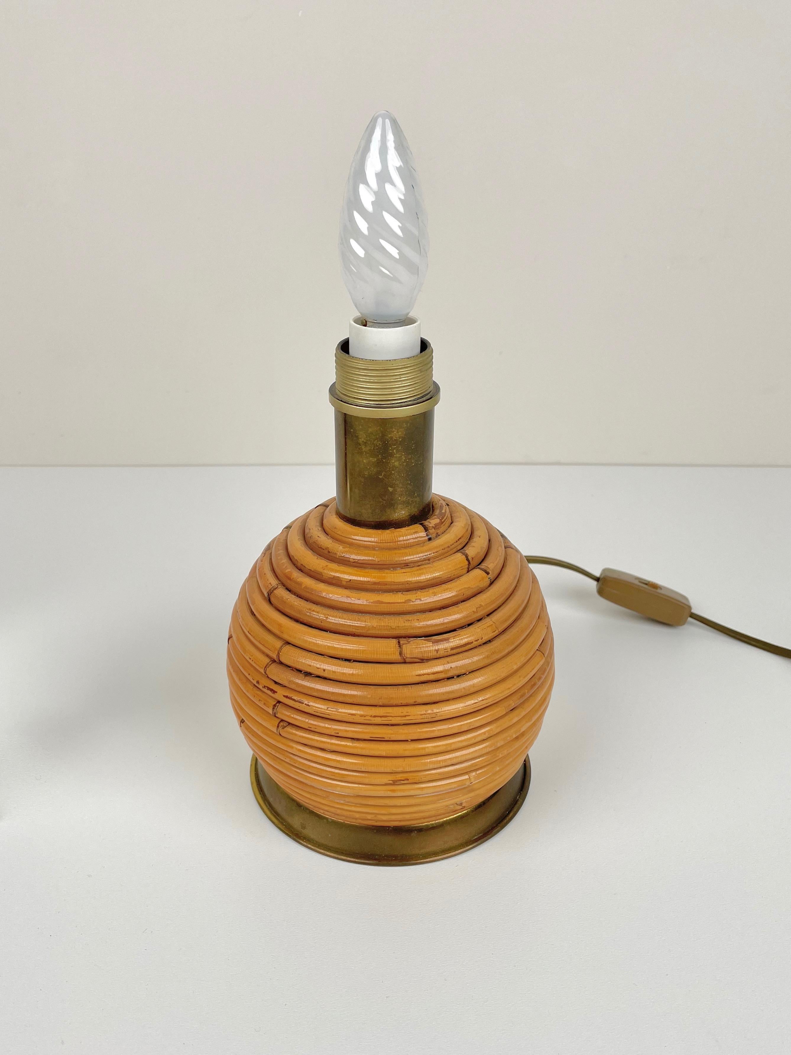 Globe-shaped vintage rattan table lamp with brass structure and base made in Italy in the 1970s.