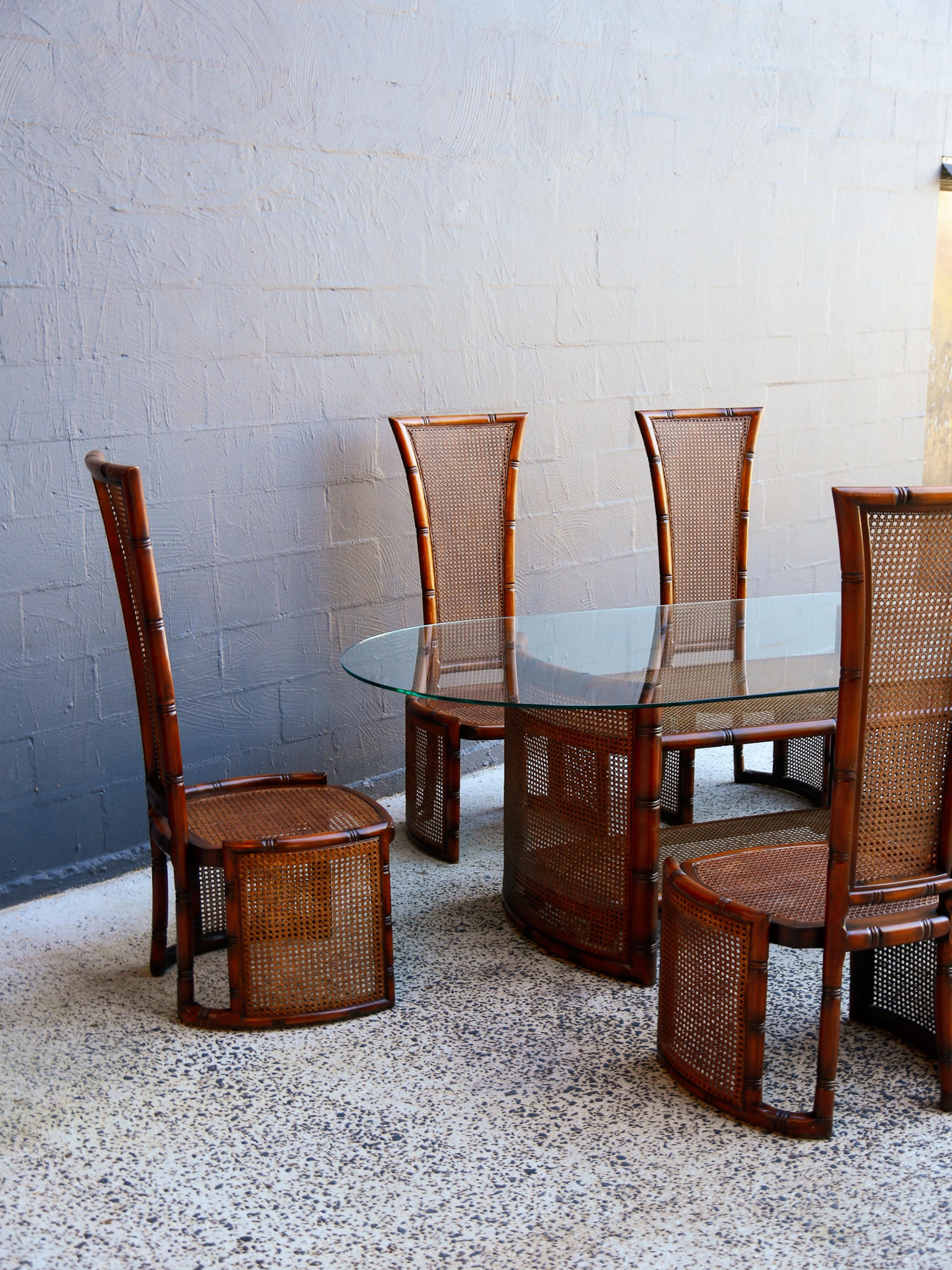 This elegant 1970s Italian dining set by Marzio Cecchi for Studio Most comprises a striking oval glass-top table and six high-back dining chairs in rattan and stained wood. A masterful example of mid-century Italian organic modernism, the set blends