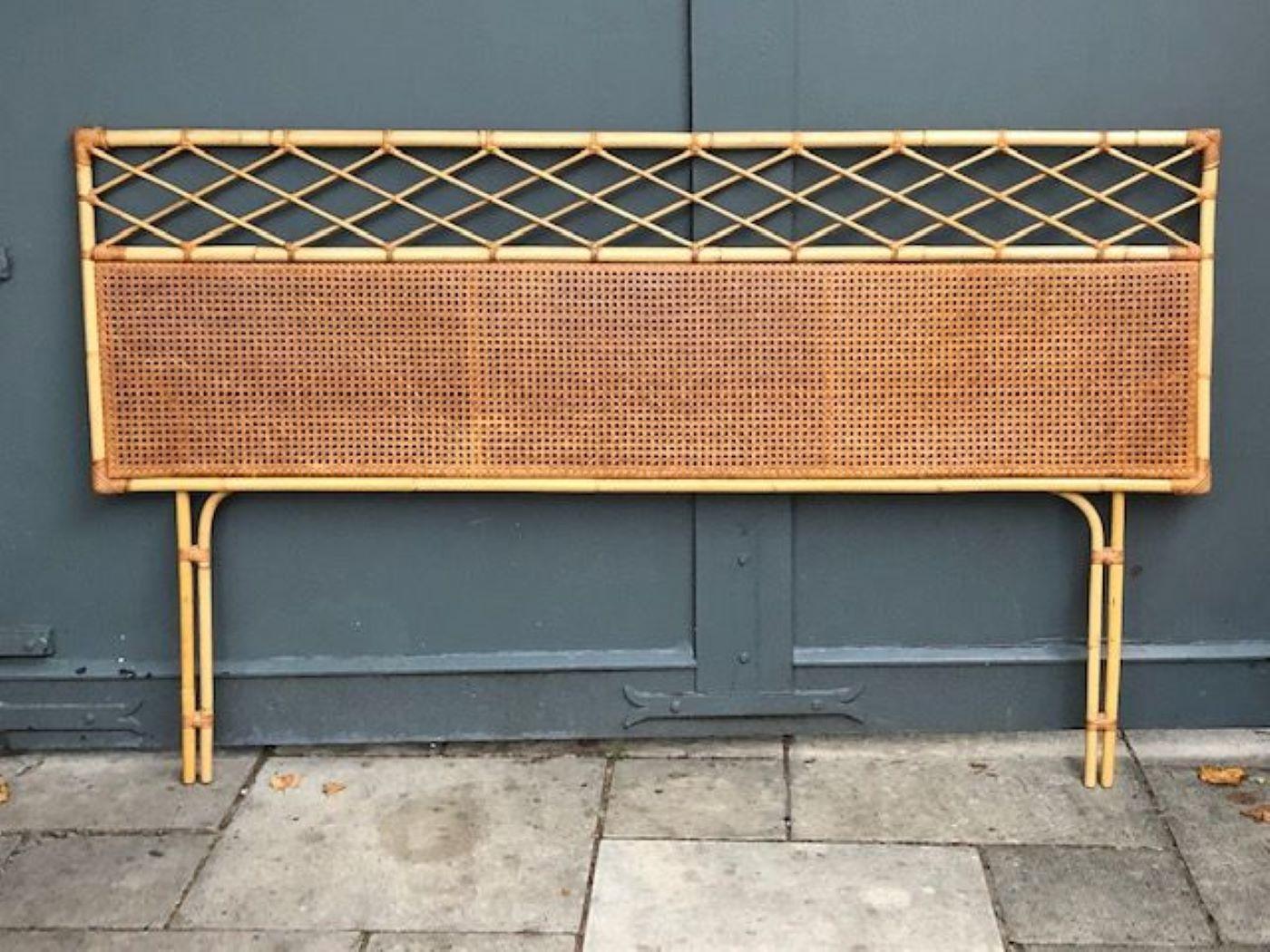 Mid-Century Modern rattan / cane super king headboard (6’ft), Italian, 1970s

Mid-Century Modern rattan / cane rectangular shaped headboard, with a large French cane matting panel, below a woven rattan diamond pattern, on cane legs. To fit a 6ft