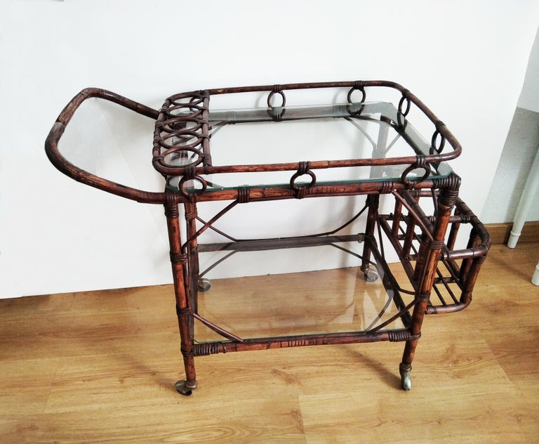 Mid-Century Modern rattan cart bar, 1950s.

Cart bar, drink or tee  cart
  This Cart bar is ideal for interior or exterior made with wicker and glass, it is very decorative and perfect to serve on your terrace or garden.
  It has two floors several