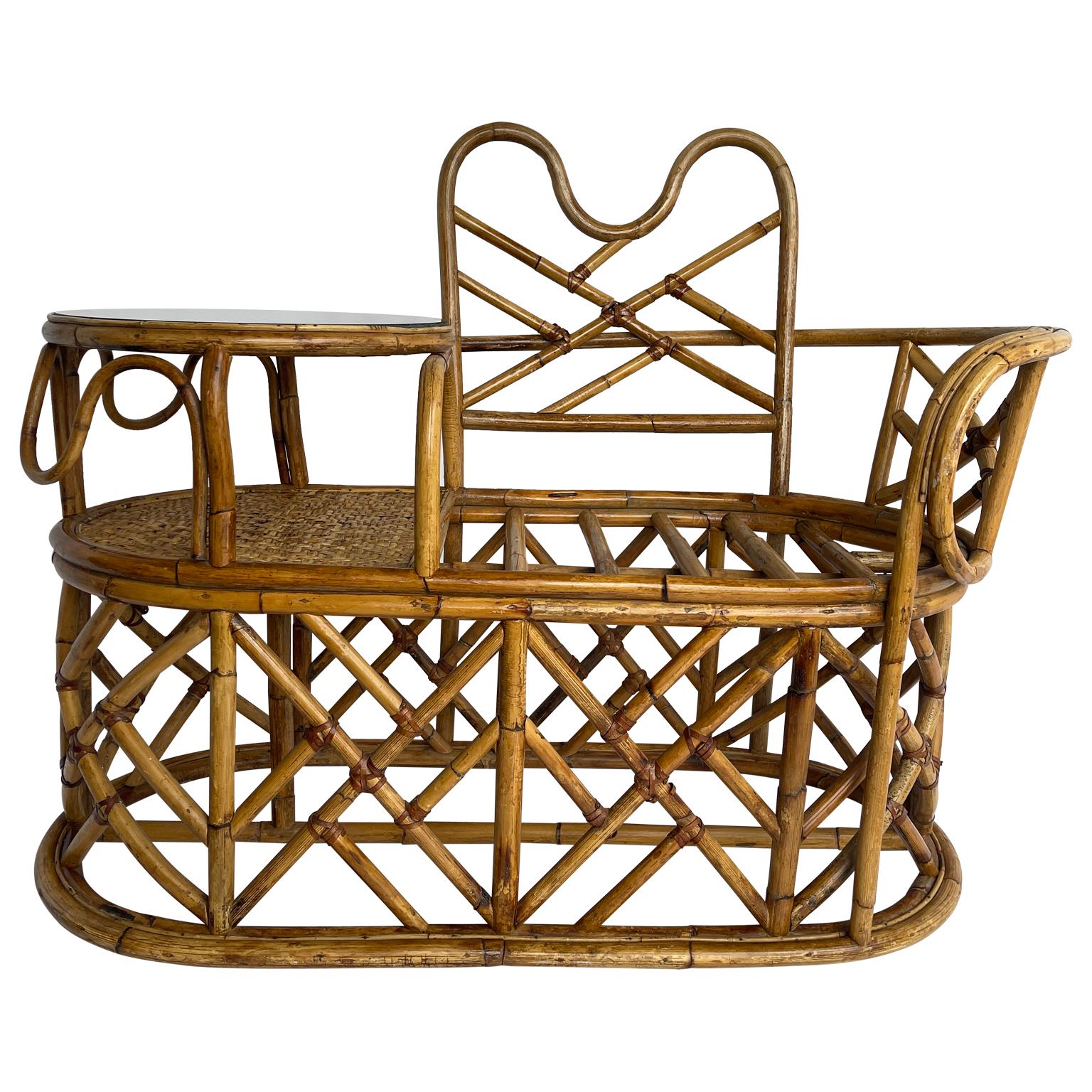 Mid-Century Modern Rattan gossip chair with glass side table. This lovely rattan chair or bench is as functional as it is beautiful and charming. The graceful curves of the rattan are elegant yet very sturdy. Picture yourself relaxing while chatting