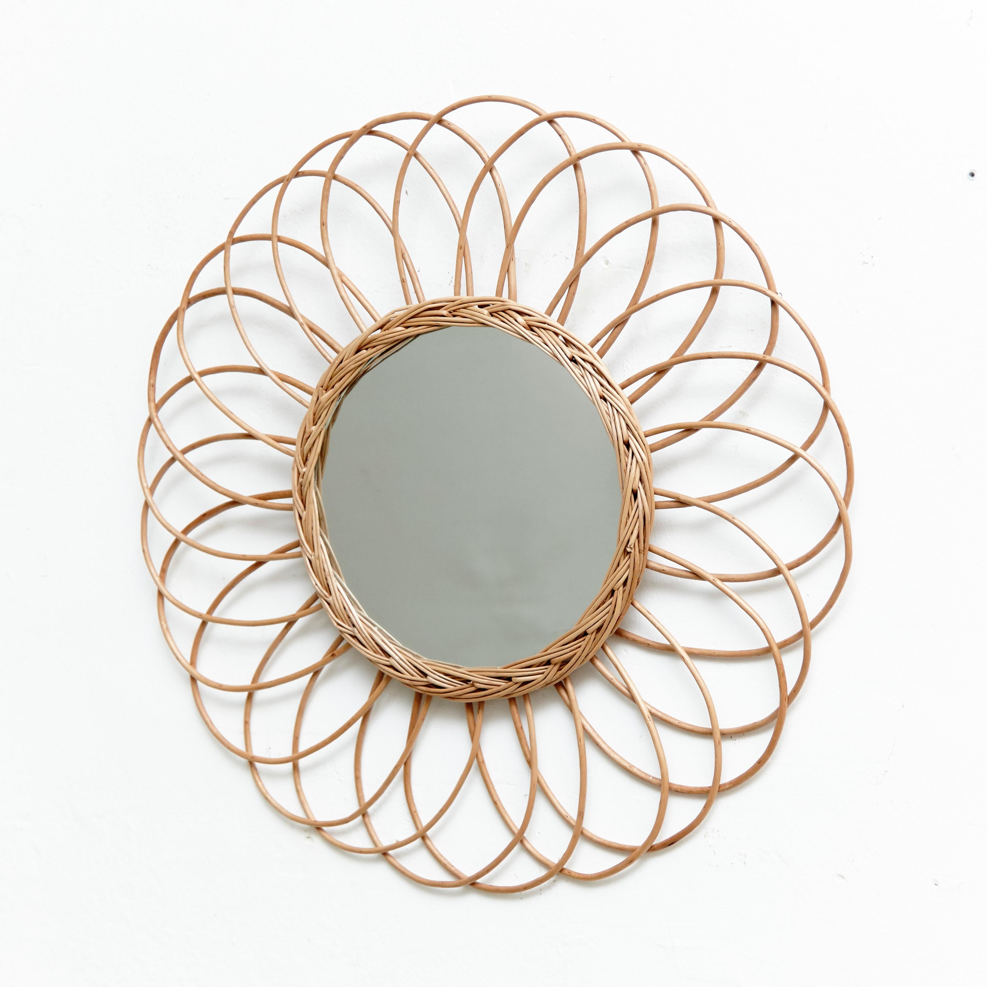 Mid-Century Modern rattan handcrafted sunburst wall mirror, circa 1960
Traditionally manufactured in France.
By unknown designer.

In original condition with minor wear consistent of age and use, preserving a beautiful patina.

 