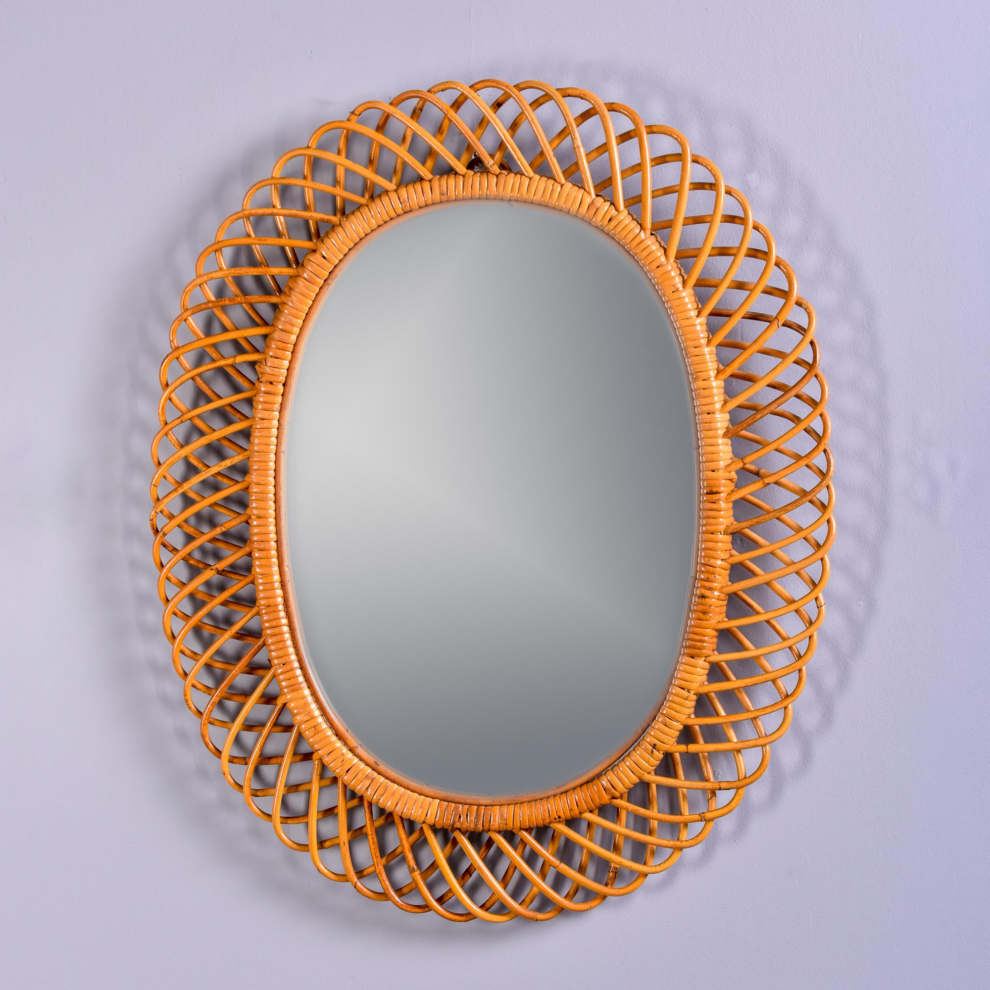 Found in Italy, this circa 1970s oval mirror has a woven rattan frame with a natural color finish. Unknown maker. Very good vintage condition. Additional mirrors in this style available at the time of this posting. Please inquire if interested.