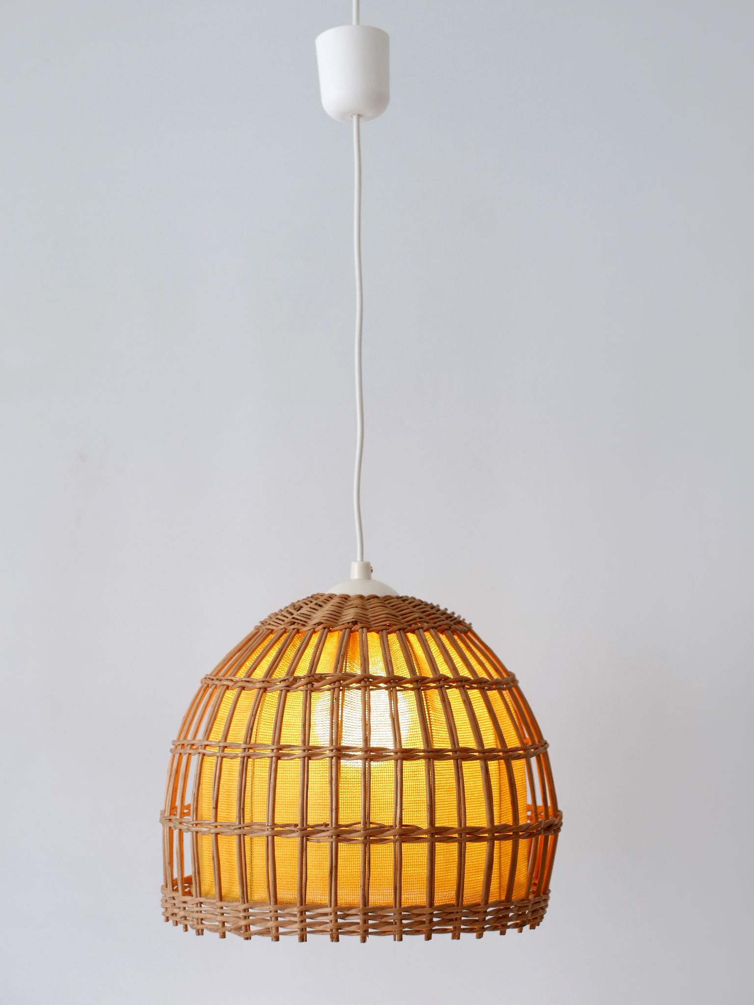 Lovely & highly decorative Mid-Century Modern pendant lamp or hanging light. Designed & manufactured in Germany, 1960s.

Executed in rattan and fabric, the pendant lamp comes with 1 x E27 / E26 Edison screw fit bulb socket, is rewired and in working