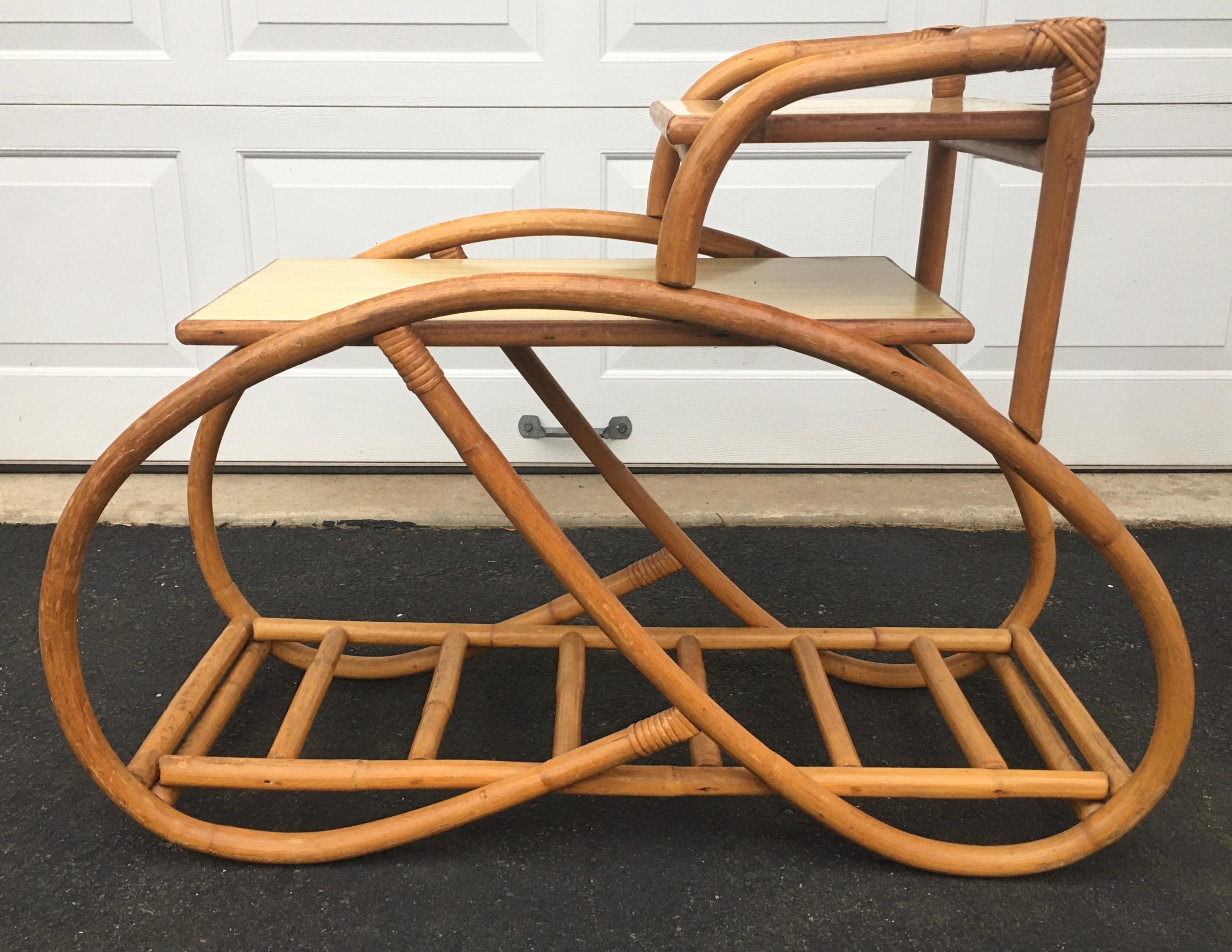 Three quarter pretzel rattan side table in original vintage condition. Features amazing organic and sculptural bentwood bamboo wood frame. Features three tiers, top two table tiers are hardwood tops covered in original blonde laminate. Bottom tier