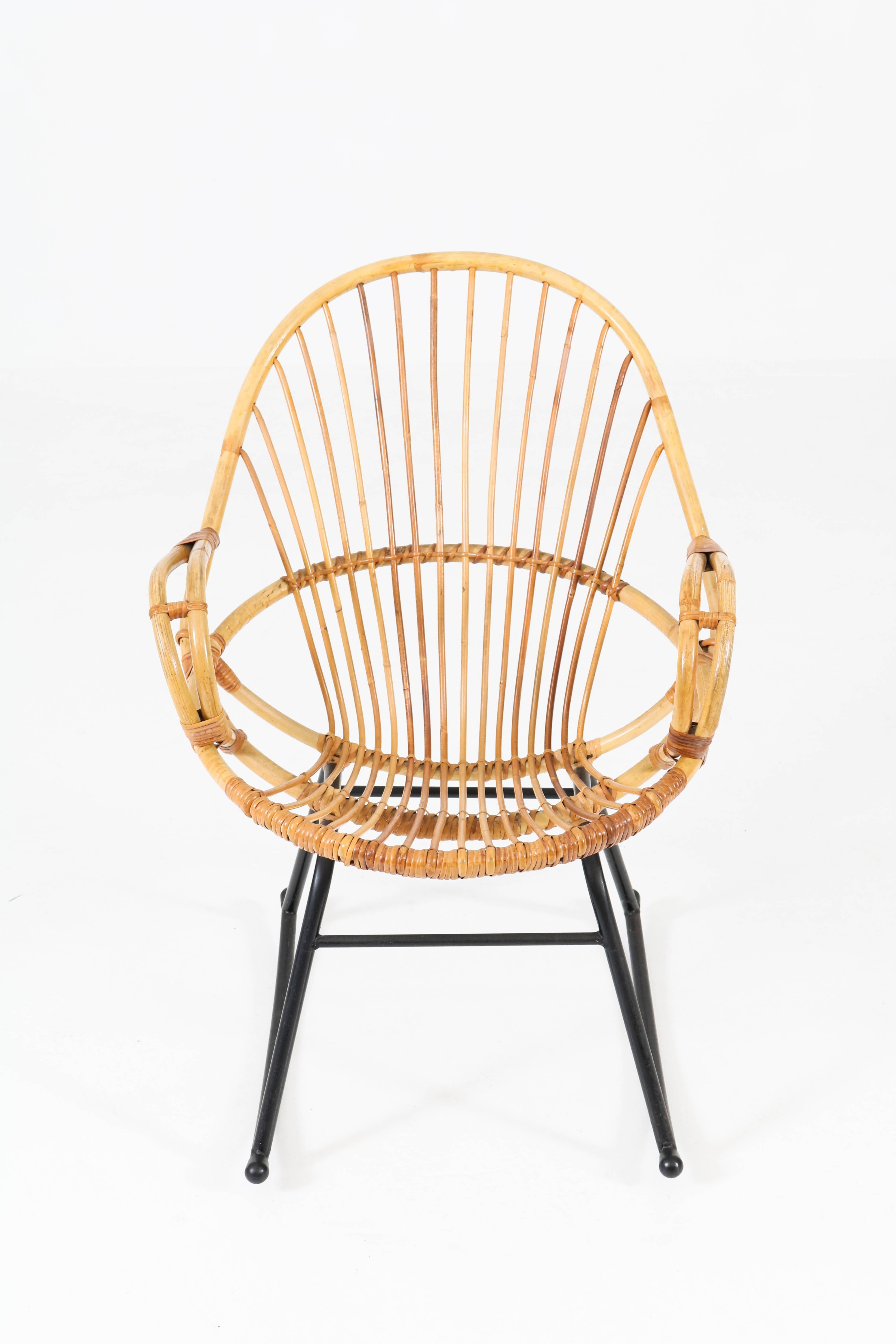 Elegant Mid-Century Modern rattan rocking chair by Gebroeders Jonker for Rohe, 1960s.
Black lacquered metal base with rattan seating.
In good original condition with minor wear consistent with age and use,
preserving a beautiful patina.